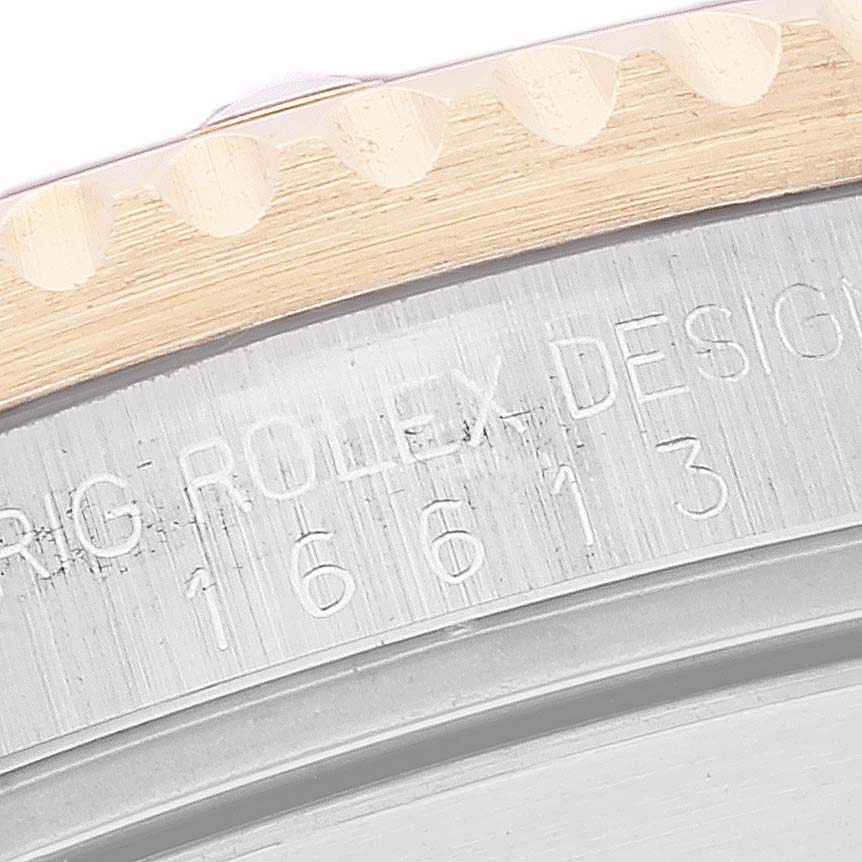 The image shows a close-up of the engraved reference number on the side of a Rolex Submariner 16613 Men's Steel and Gold (two tone) Champagne Dial 16613 Men's Steel and Gold (two tone) Champagne Dial watch case and bezel.