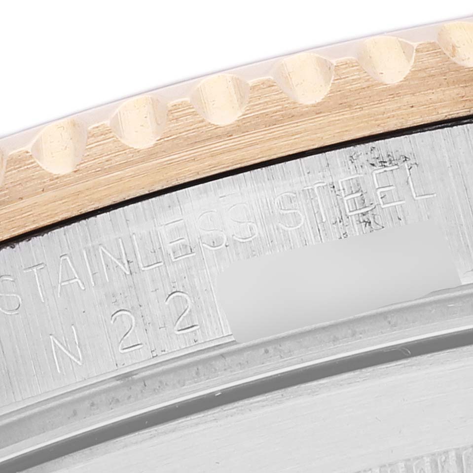 This is a close-up of the stainless steel caseback of a Rolex Submariner 16613 Men's Steel and Gold (two tone) Champagne Dial 16613 Men's Steel and Gold (two tone) Champagne Dial, showing engraved text and part of the bezel.