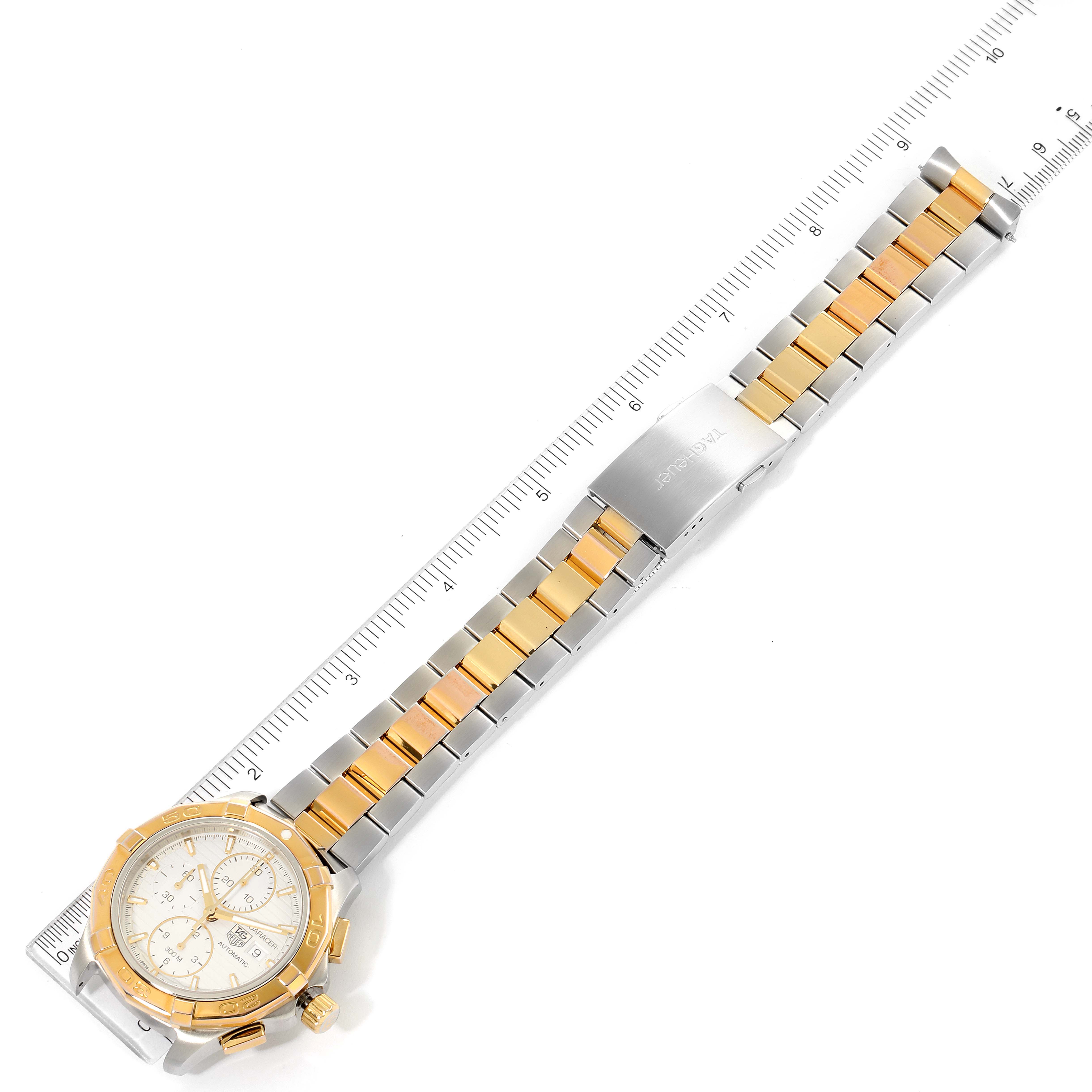 The Tag Heuer Aquaracer CAP2120.BB0834 Men's Steel and Gold (two tone) Silver Dial CAP2120.BB0834 Men's Steel and Gold (two tone) Silver Dial watch is displayed from above, showing the face, bezel, and full bracelet against a measuring ruler.