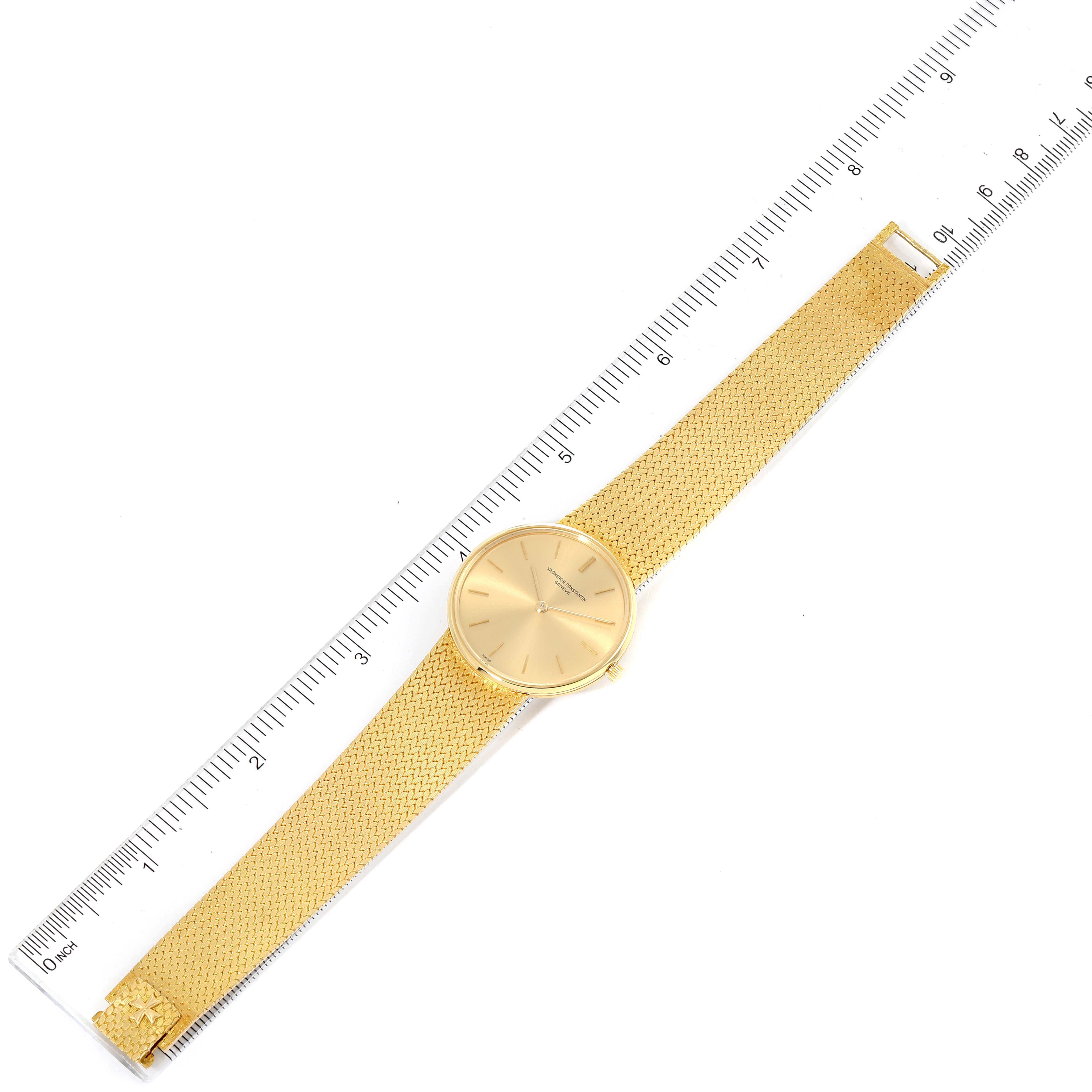 The image shows a top-down view of a Vacheron Constantin Patrimony 6872 Men's Yellow Gold Champagne Dial 6872 Men's Yellow Gold Champagne Dial watch with its full gold mesh strap placed next to a ruler.