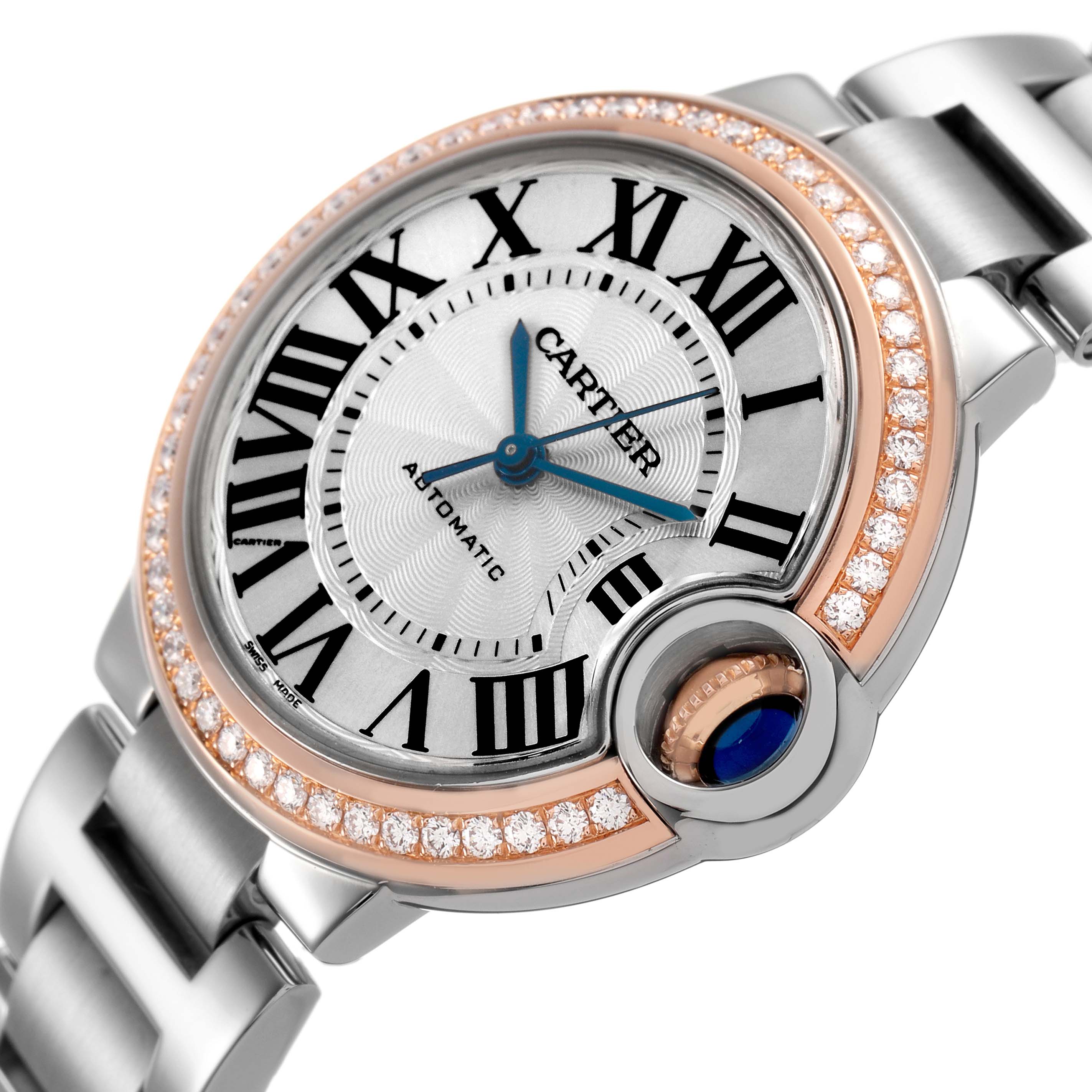 The Cartier Ballon Bleu WE902080 Women's Stainless Steel Silver Dial watch is shown from a slight side angle, highlighting its Roman numeral dial, blue hands, and diamond-encrusted bezel.