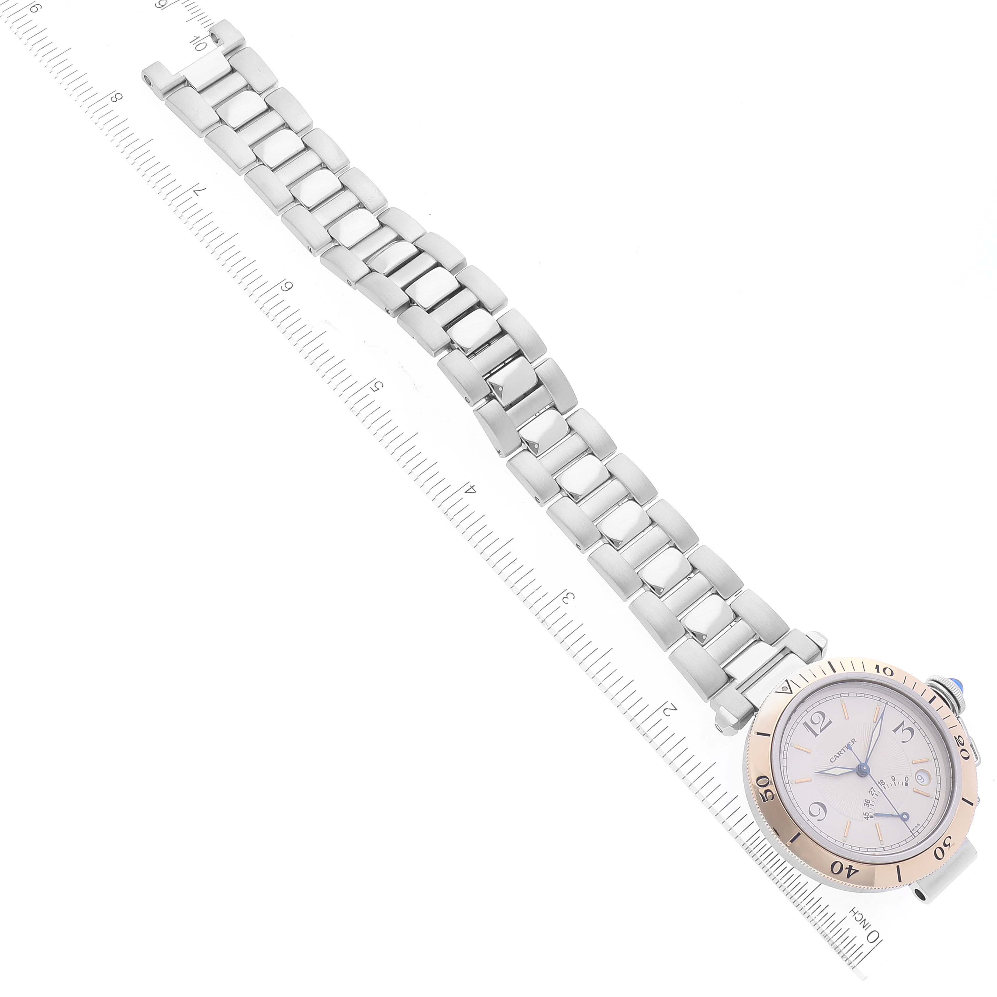 The image shows the Cartier Pasha W3101255 Men
s Steel and Gold (two tone) Silver Dial W3101255 Men
s Steel and Gold (two tone) Silver Dial model watch with its bracelet extended and positioned diagonally next to a ruler.