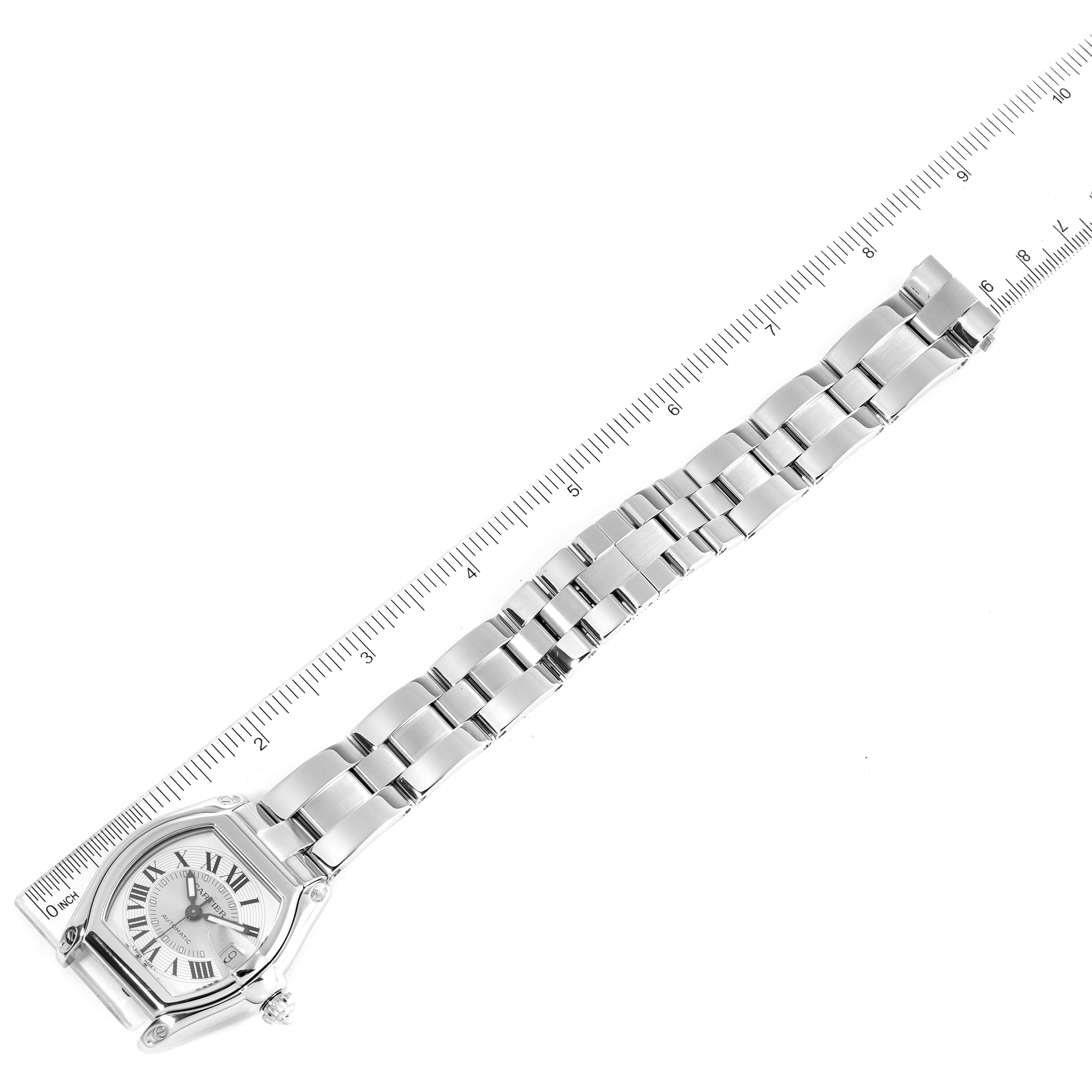 The Cartier Roadster W62000V3 Men
s Stainless Steel Silver Dial W62000V3 Men
s Stainless Steel Silver Dial watch is shown from an overhead angle, displaying the face and full metal bracelet beside a ruler.