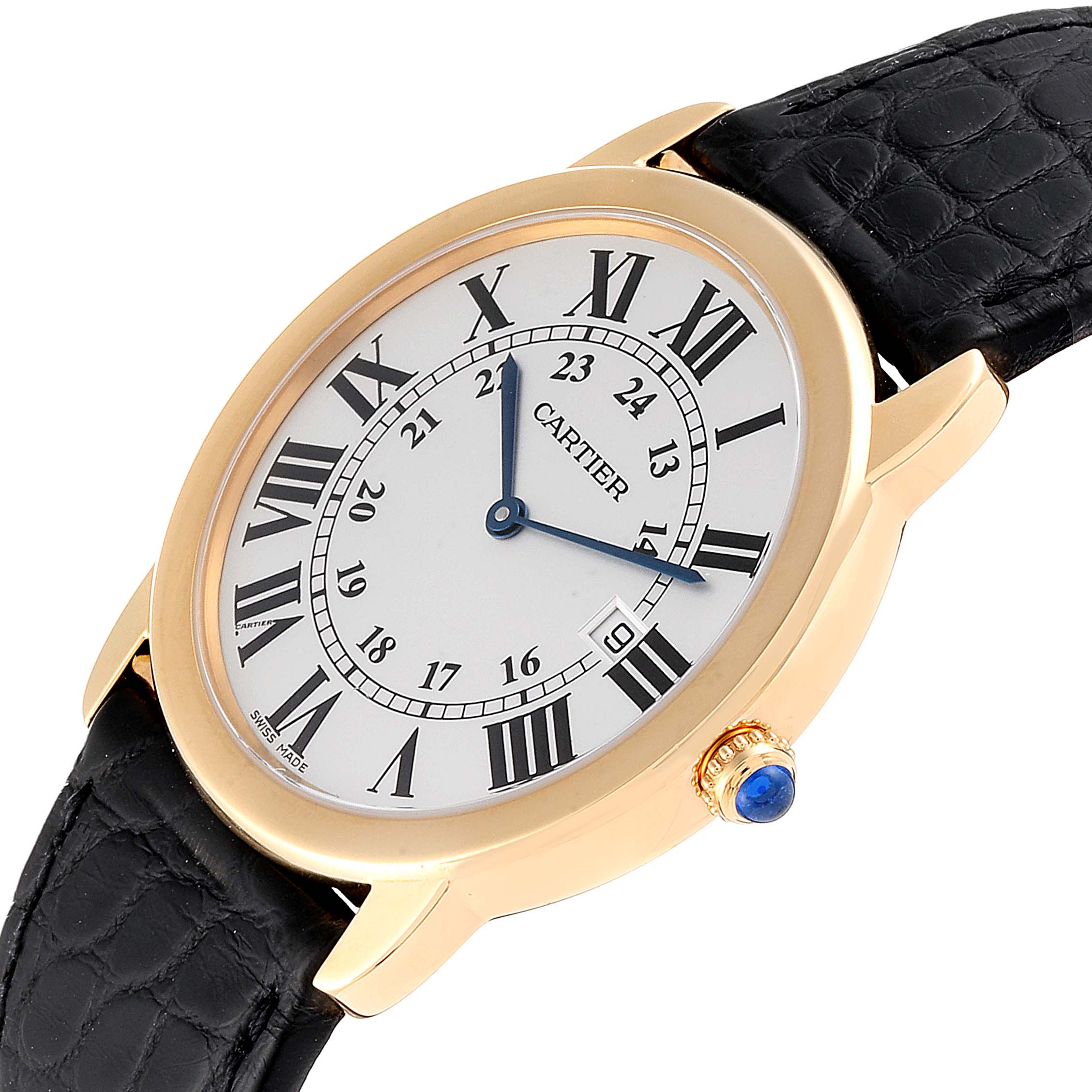 The Cartier Ronde W6700455 Women
s Yellow Gold Silver Dial W6700455 Women
s Yellow Gold Silver Dial watch is shown at a slight angle, displaying the face, Roman numeral dial, gold casing, and black leather strap.