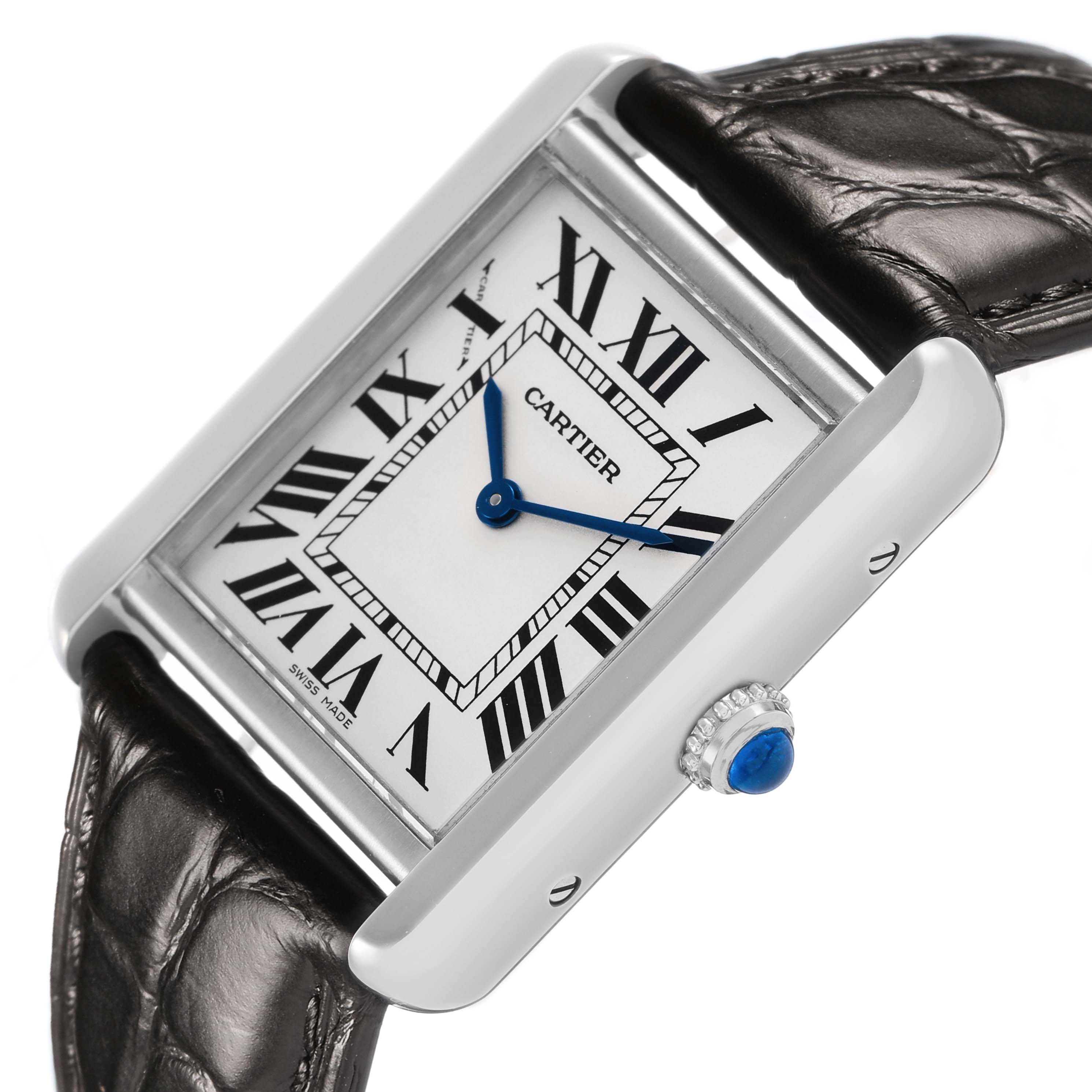 The Cartier Tank Solo W1018255 Women's Stainless Steel Silver Dial watch is shown at an angle highlighting its face, blue hands, Roman numerals, case, and crown with a blue stone.
