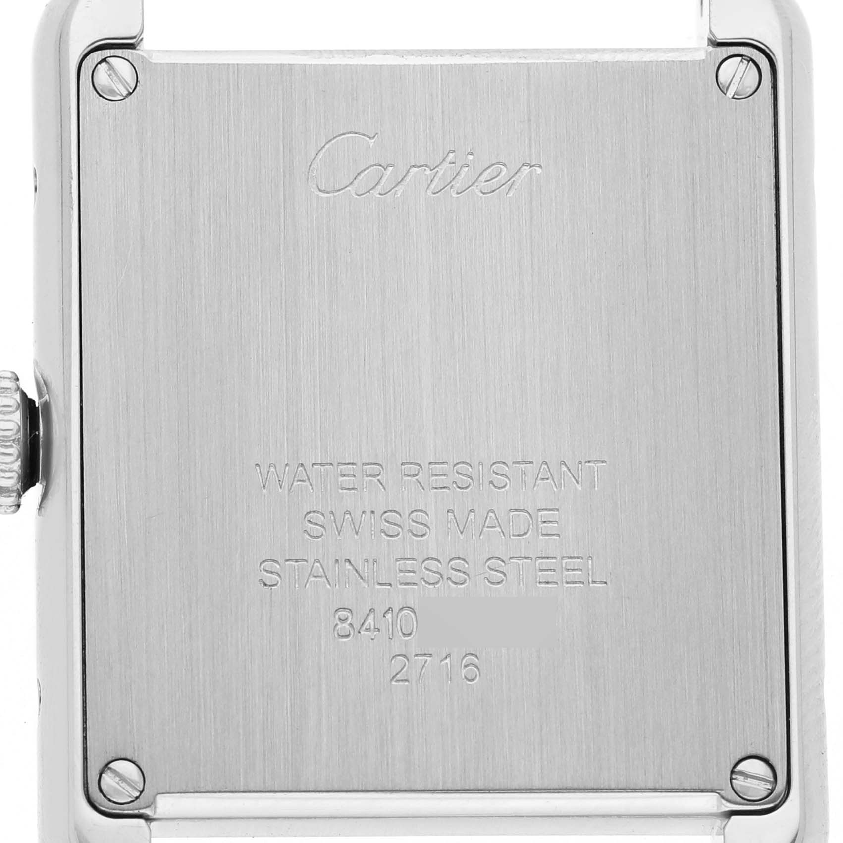 The image shows the back case of a Cartier Tank Solo W1018255 Women's Stainless Steel Silver Dial watch, featuring engraving details and screws.