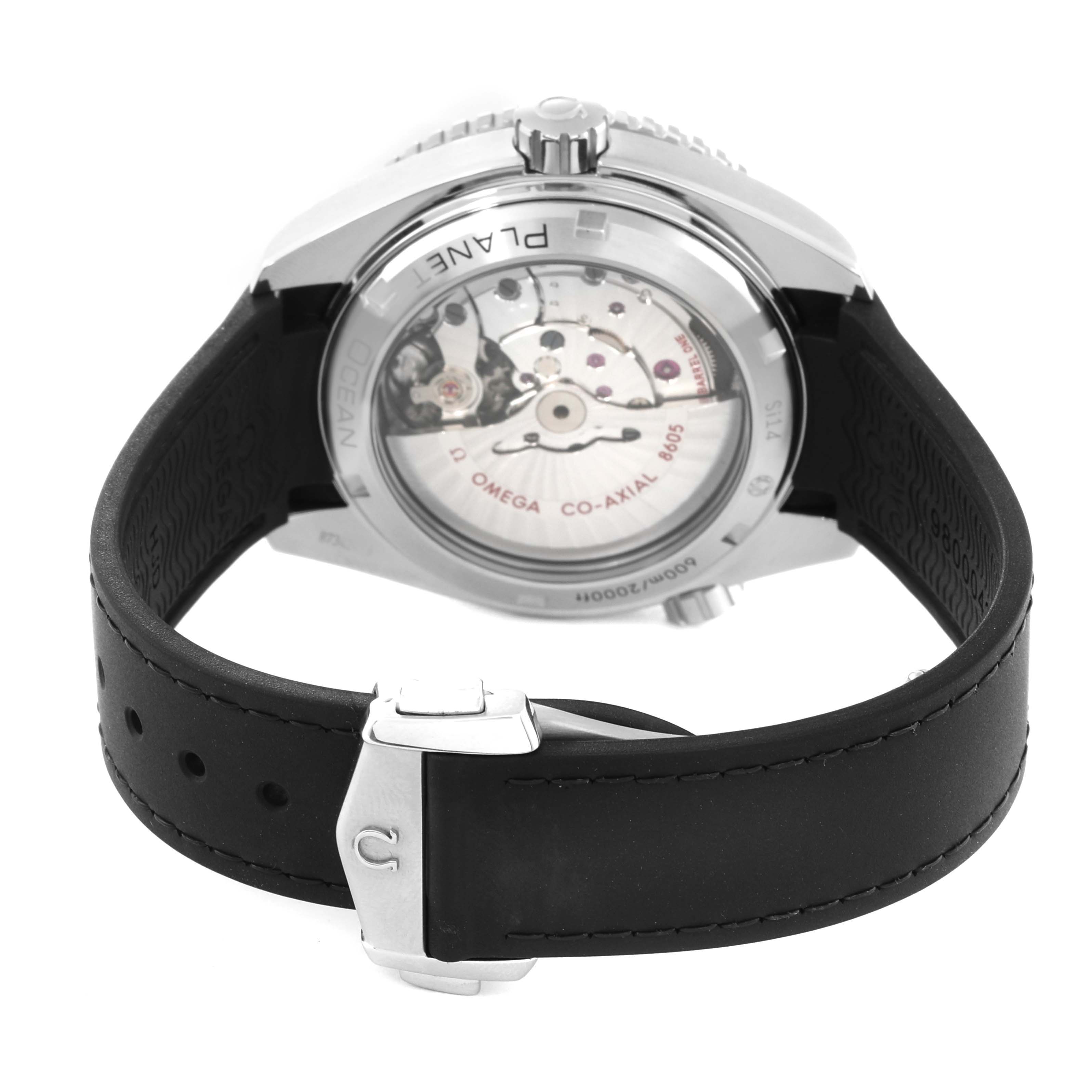 The image shows the back view of an Omega Seamaster watch, focusing on the movement and the black strap.