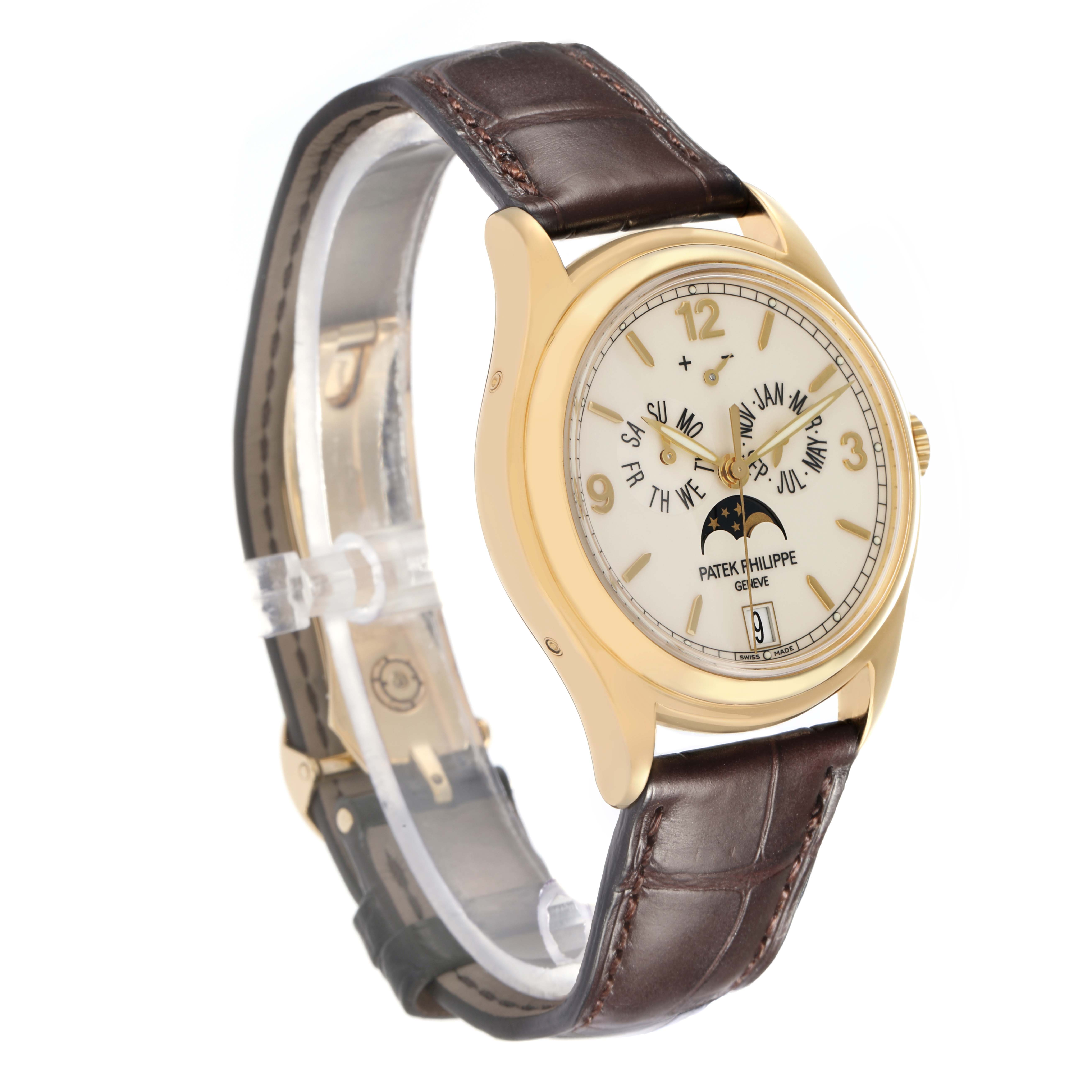 The Patek Philippe Complications 5146J watch is shown at a three-quarter angle, displaying its gold case, dial with calendar features, moon phase, and leather strap.