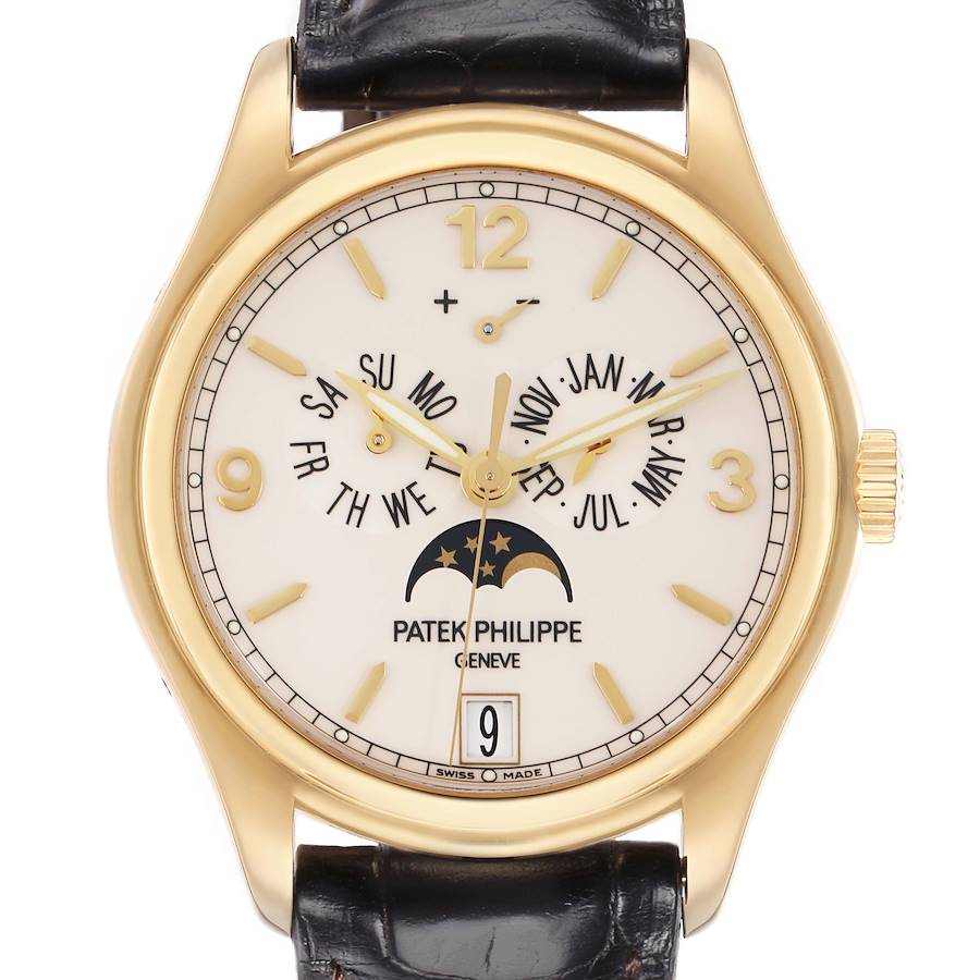 The Patek Philippe Complications 5146J watch is shown from the front, displaying its gold casing, dial with calendar functions, moon phase, and black leather strap.
