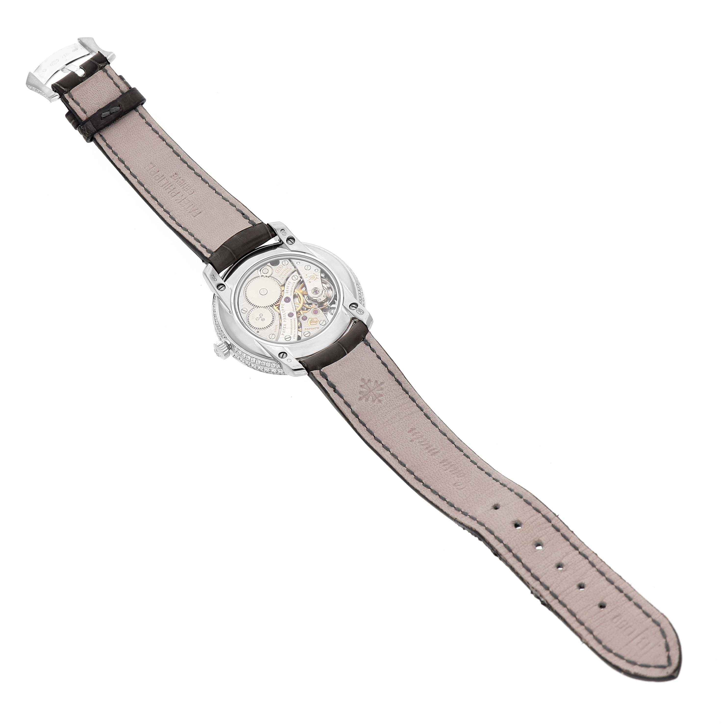 The image shows the back view of the Patek Philippe Complications 4968G Women's White Gold Mother of Pearl Dial watch, highlighting its mechanical movement and strap.