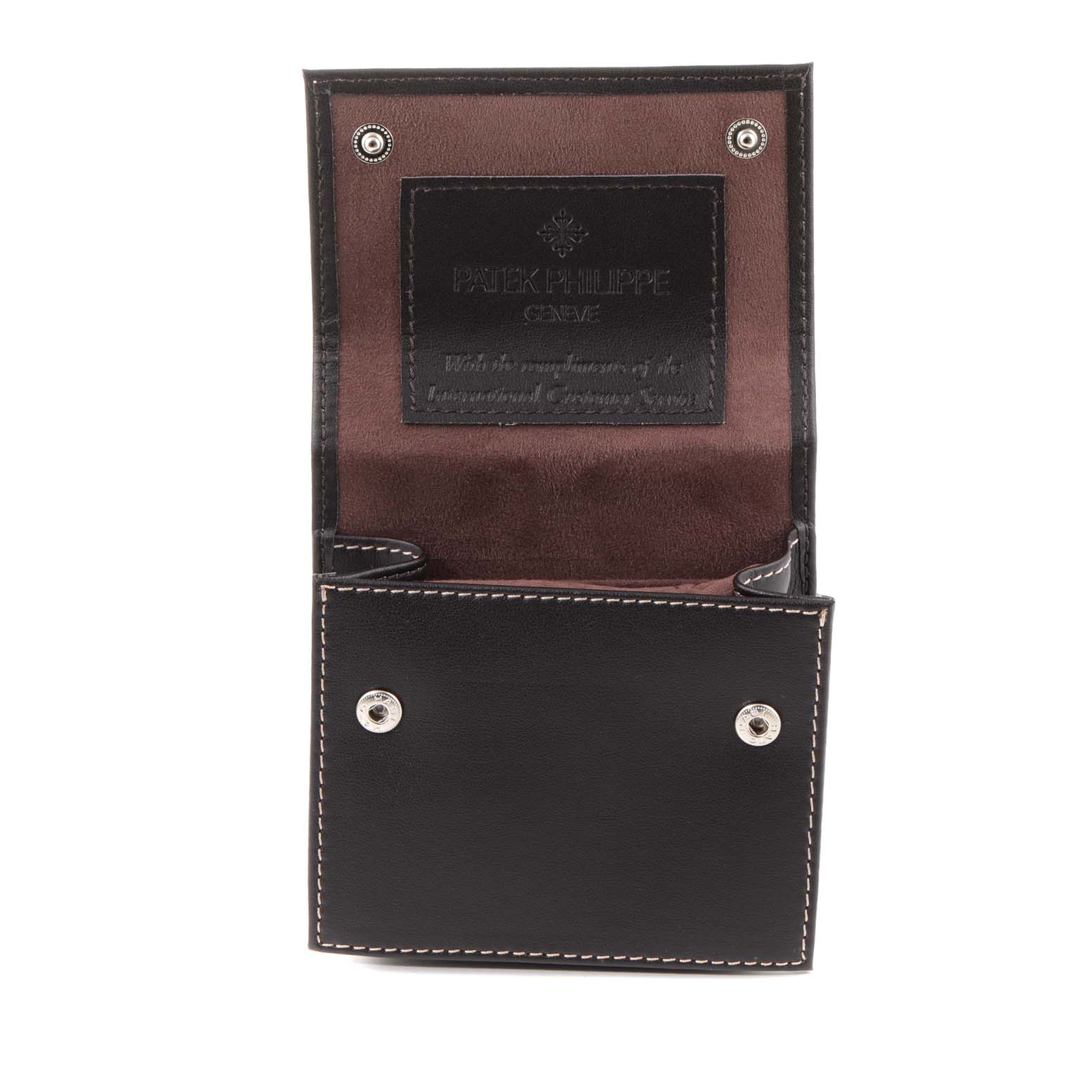 The image shows an open leather case for the Patek Philippe Twenty-4 4910/10A-010 Women's Stainless Steel Silver Dial 4910/10A-010 Women's Stainless Steel Silver Dial watch, displaying its interior and snap button closures.