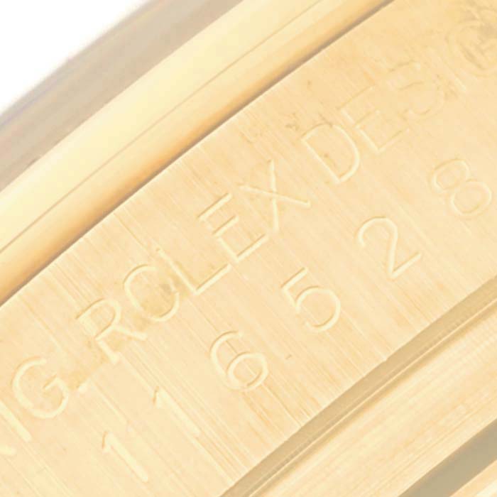 This close-up image shows the engraved side of the Rolex Daytona 116528 Men
s Yellow Gold Black Dial 116528 Men
s Yellow Gold Black Dial watch, highlighting the brand and design serial numbers.