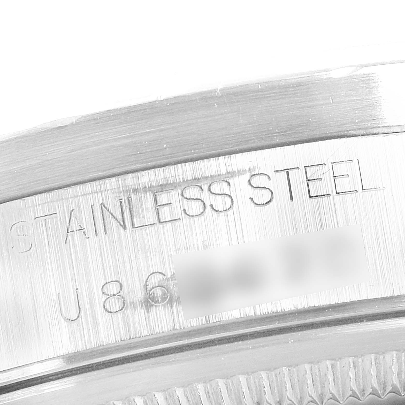 This is an up-close view of the side of a stainless steel Rolex Date 15210 Men's Stainless Steel Blue Dial 15210 Men's Stainless Steel Blue Dial model, showing the serial number and material engraving.