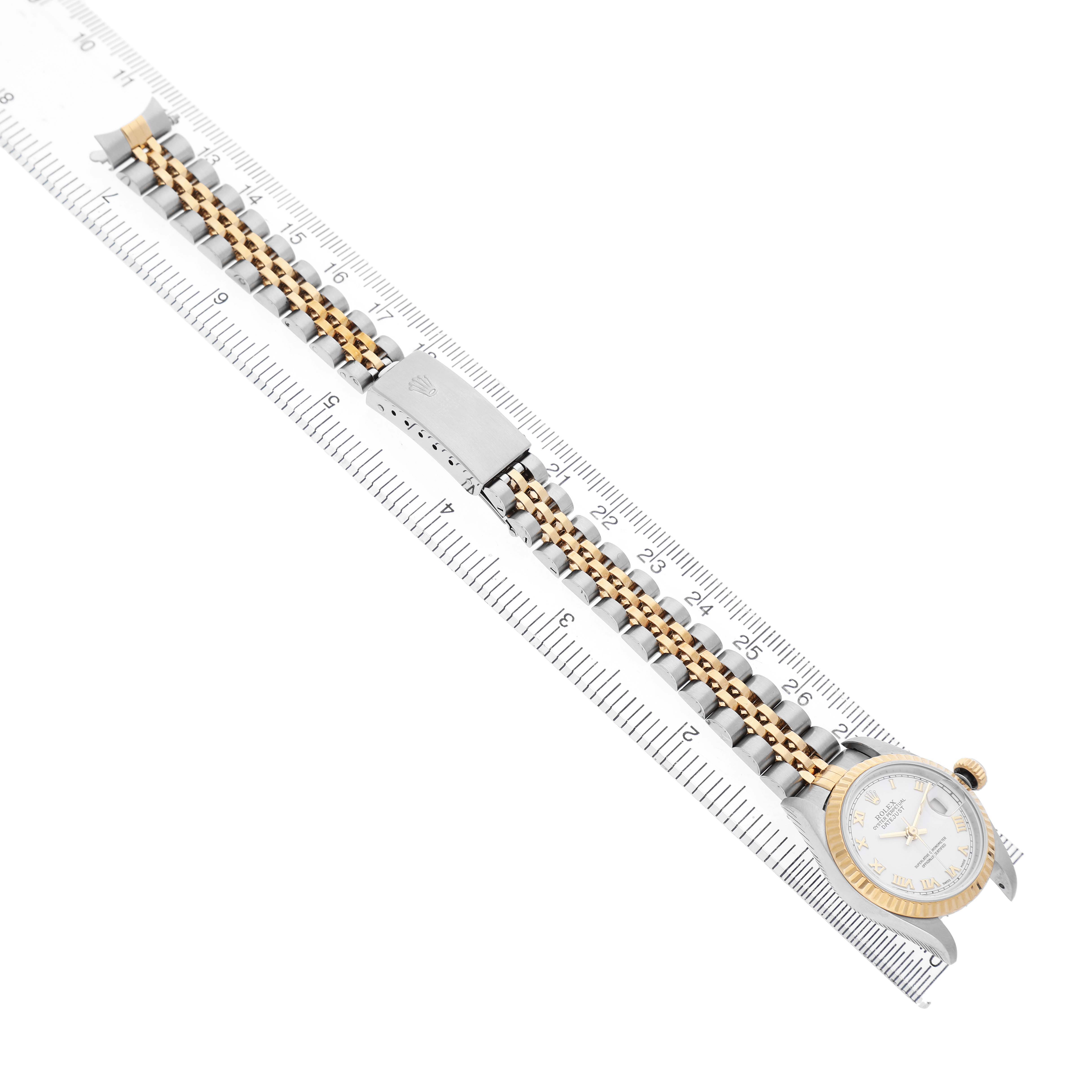 The Rolex Datejust 79173 Women's Stainless Steel White Dial is shown from a top view, displaying the full bracelet, clasp, and face on a ruler for scale.