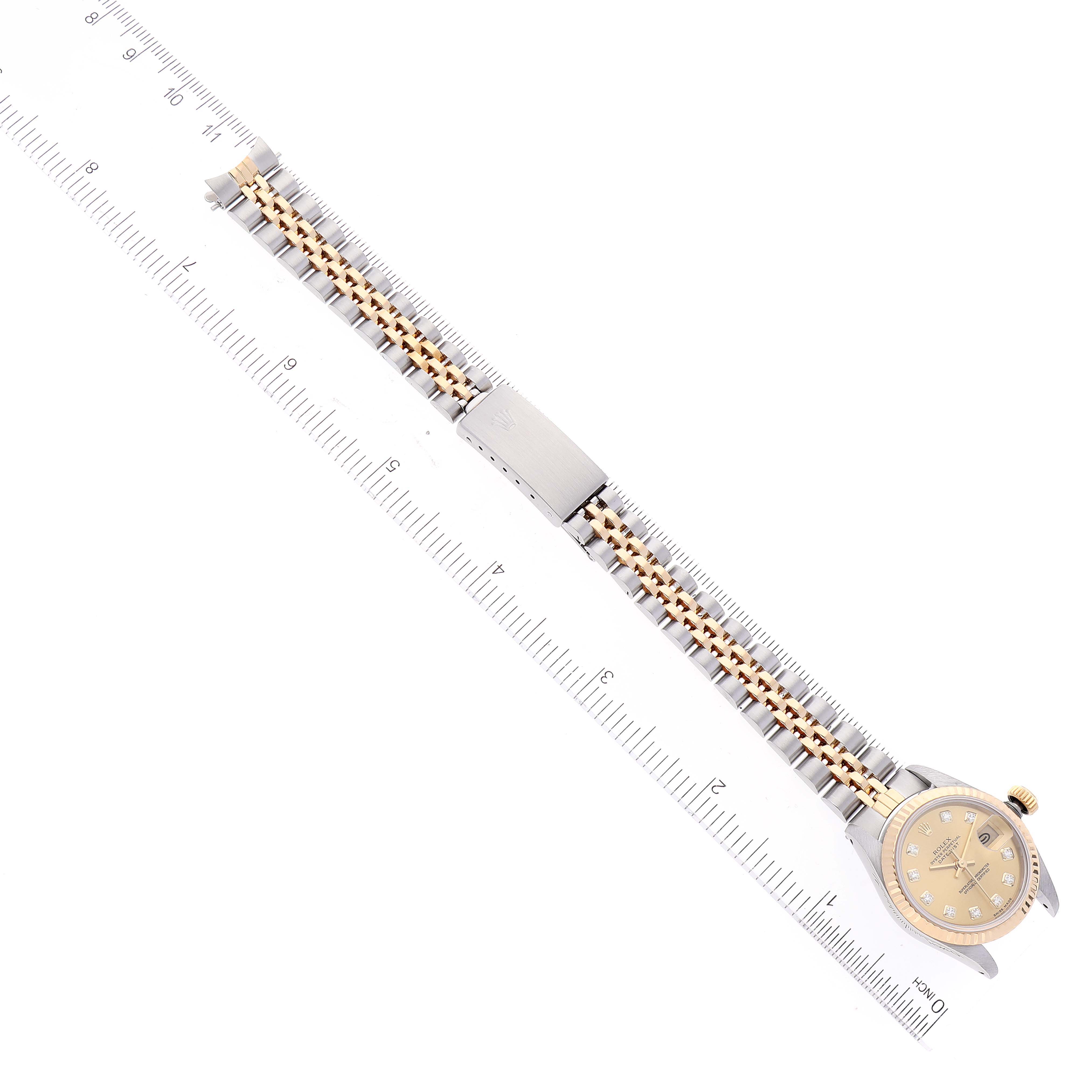 The Rolex Datejust 69173 Women's Steel and Gold (two tone) Champagne Dial 69173 Women's Steel and Gold (two tone) Champagne Dial watch is shown from a top-down angle, featuring the face, bracelet, and clasp with a ruler for scale.