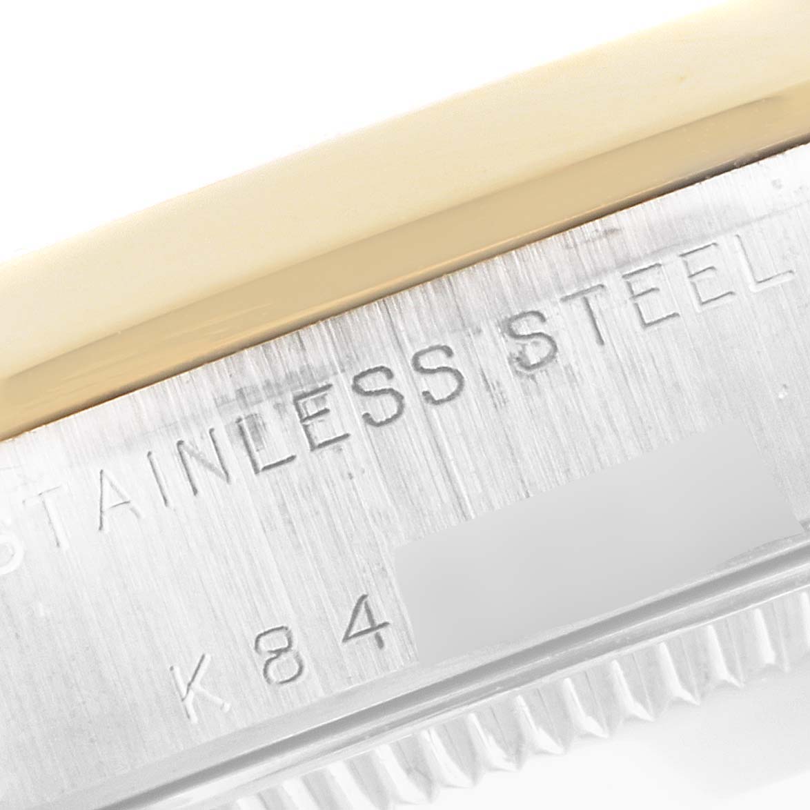 The image shows a close-up of the side of a Mid-Size Rolex watch case, displaying the "STAINLESS STEEL" engraving.