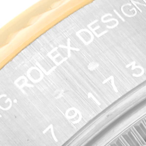 This close-up shows the engraved serial number and part of the bezel of a Rolex Datejust 79173 Women's Steel and Gold (two tone) Blue Dial 79173 Women's Steel and Gold (two tone) Blue Dial watch.