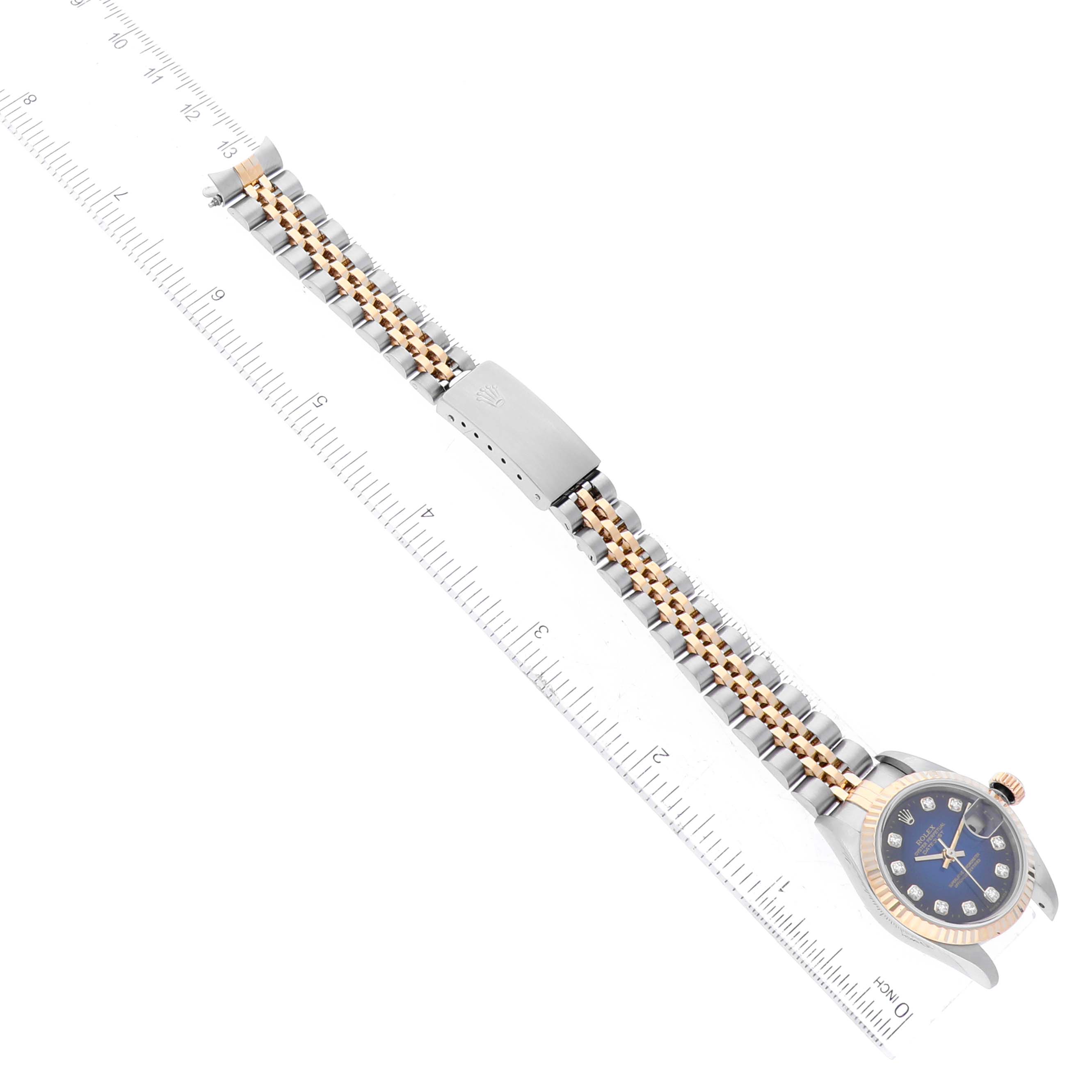 This image shows a Rolex Datejust 79173 Women's Steel and Gold (two tone) Blue Dial 79173 Women's Steel and Gold (two tone) Blue Dial watch from a top-down angle, displaying the bracelet and clasp, alongside a ruler for scale.