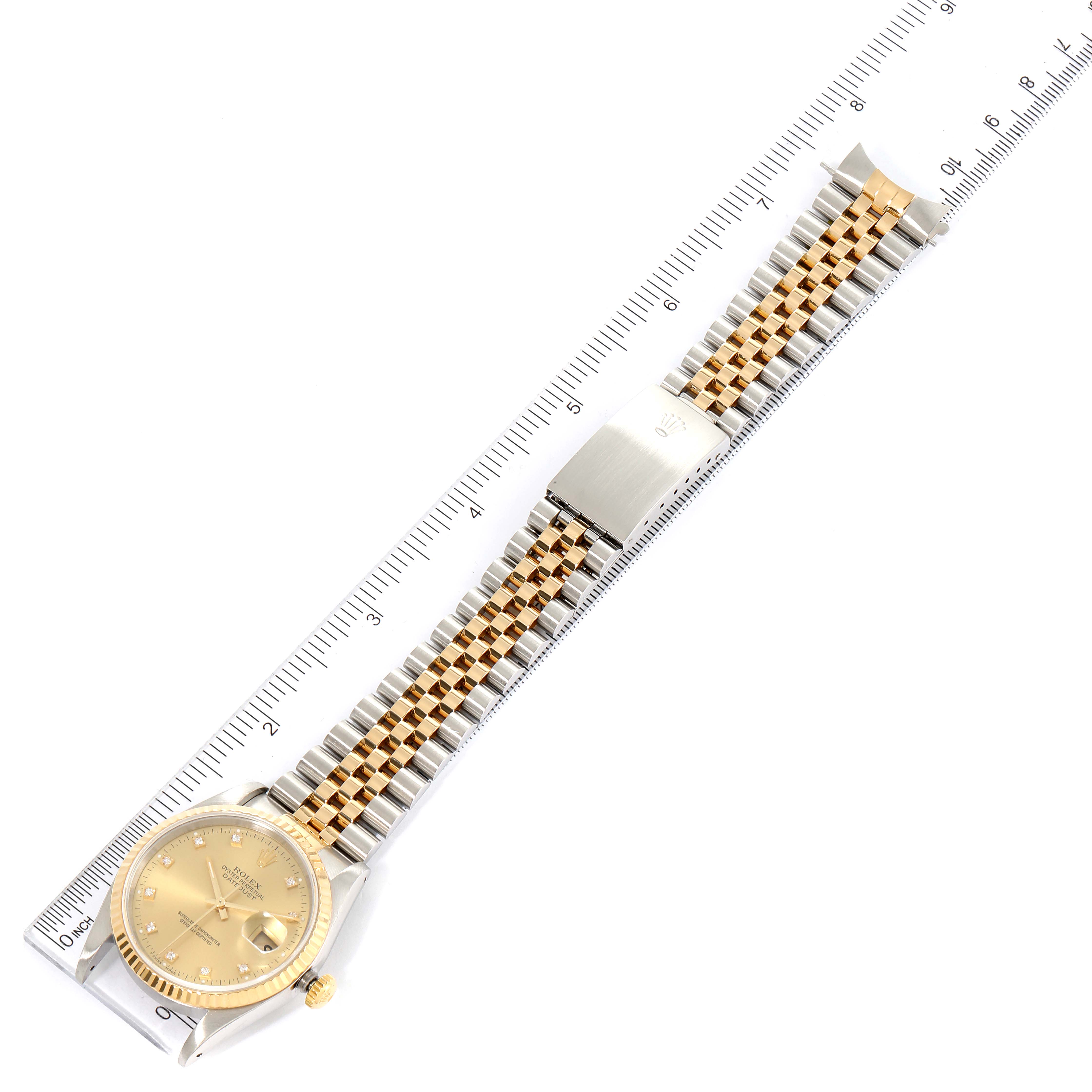 The image shows a Rolex Datejust 16233 Men's Steel and Gold (two tone) Champagne Dial 16233 Men's Steel and Gold (two tone) Champagne Dial watch laid flat, displaying the face, bezel, crown, and its two-tone metal bracelet on a ruler.