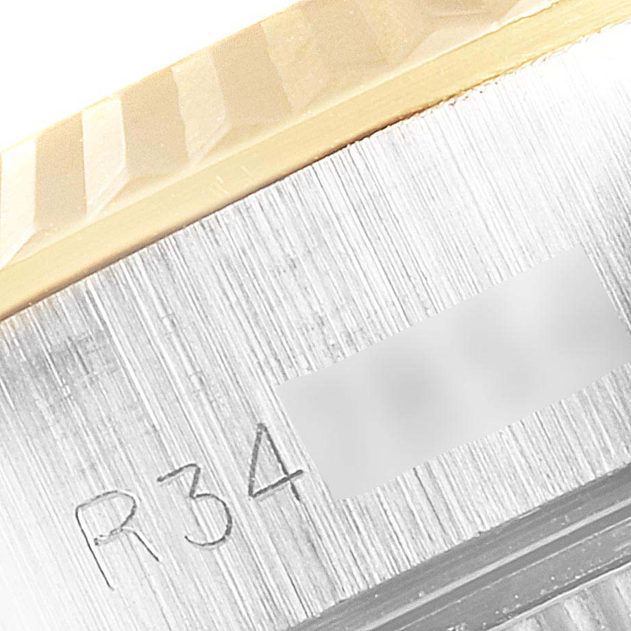 This image shows a close-up of the bezel and case side of a Rolex Datejust 69173 Women's Steel and Gold (two tone) Champagne Dial 69173 Women's Steel and Gold (two tone) Champagne Dial watch with visible engraved text.