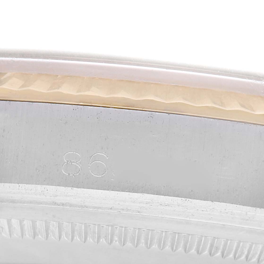 The image shows a close-up of the side of a Rolex Vintage Collection 1601 Men
s Steel and Gold (two tone) Yellow Dial watch, focusing on the engraved number and the bezel edge.