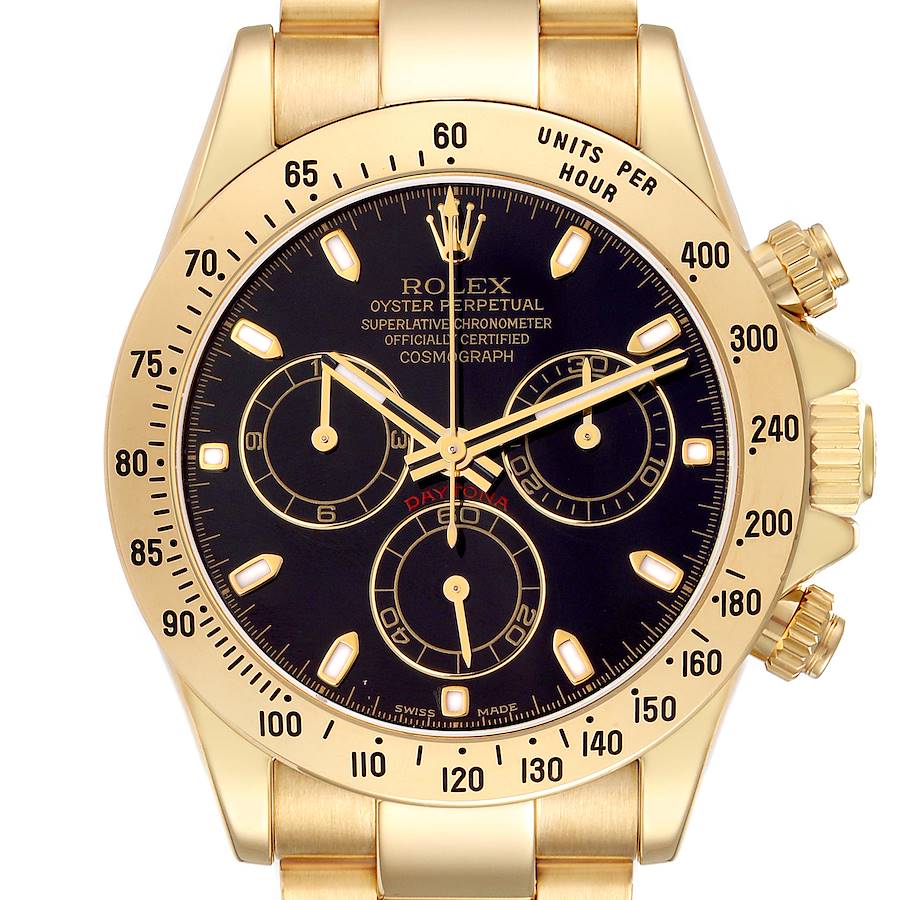 The Rolex Daytona model 116528 is shown from a front angle, highlighting the black dial, gold case, bezel, and chronograph sub-dials.