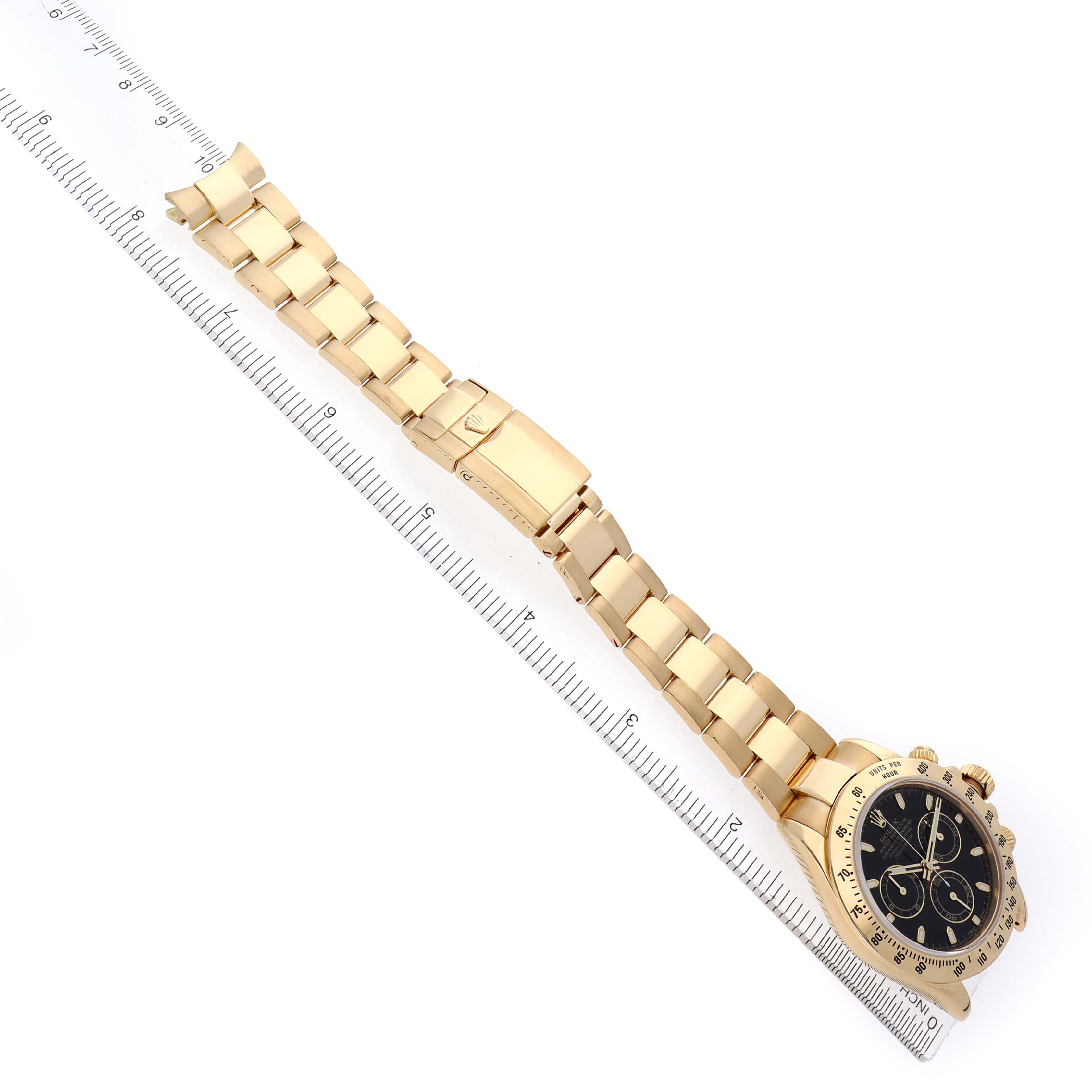 The Rolex Daytona model 116528 men
s watch is shown from an angled top view, displaying the full bracelet, clasp, case, and dial alongside a ruler for scale.