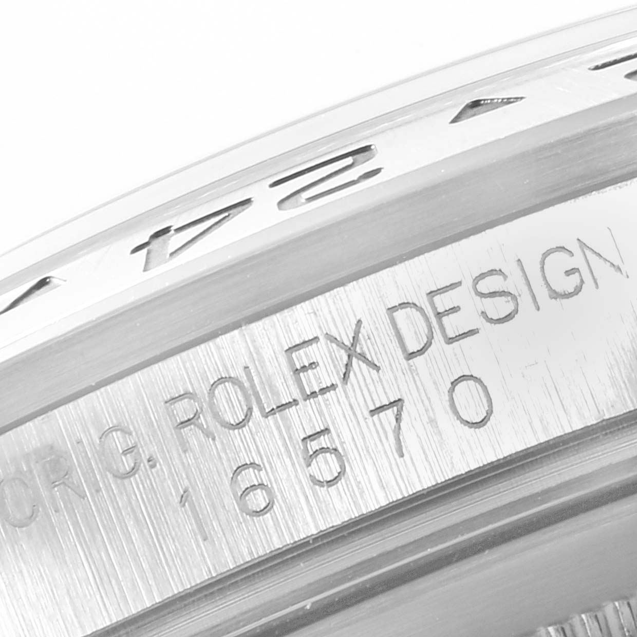 The image shows a close-up of the bezel and engraved case side of a Rolex Explorer 16570 Men's Stainless Steel White Dial 16570 Men's Stainless Steel White Dial watch.