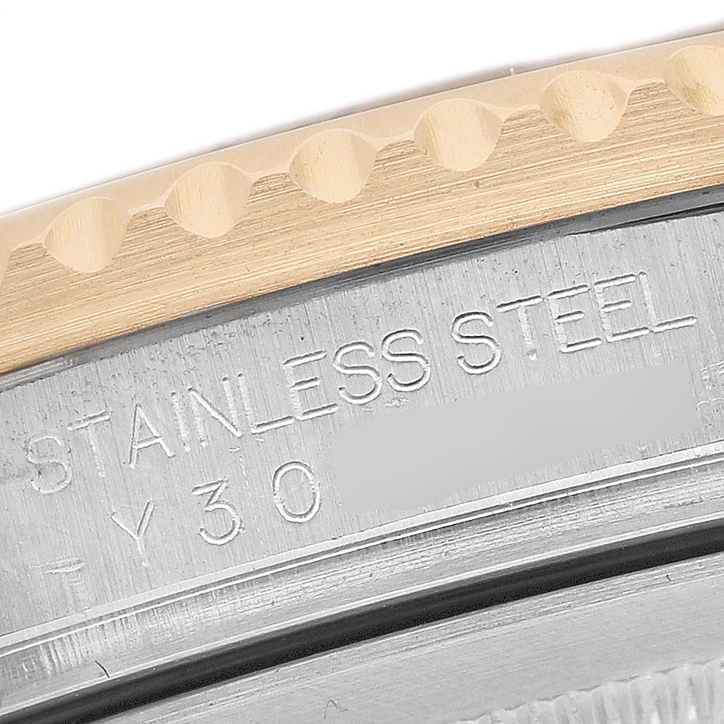 The image shows a close-up of the Rolex GMT-Master 16713 Men's Stainless Steel Brown Dial's case, revealing the bezel edge and engraved stainless steel.