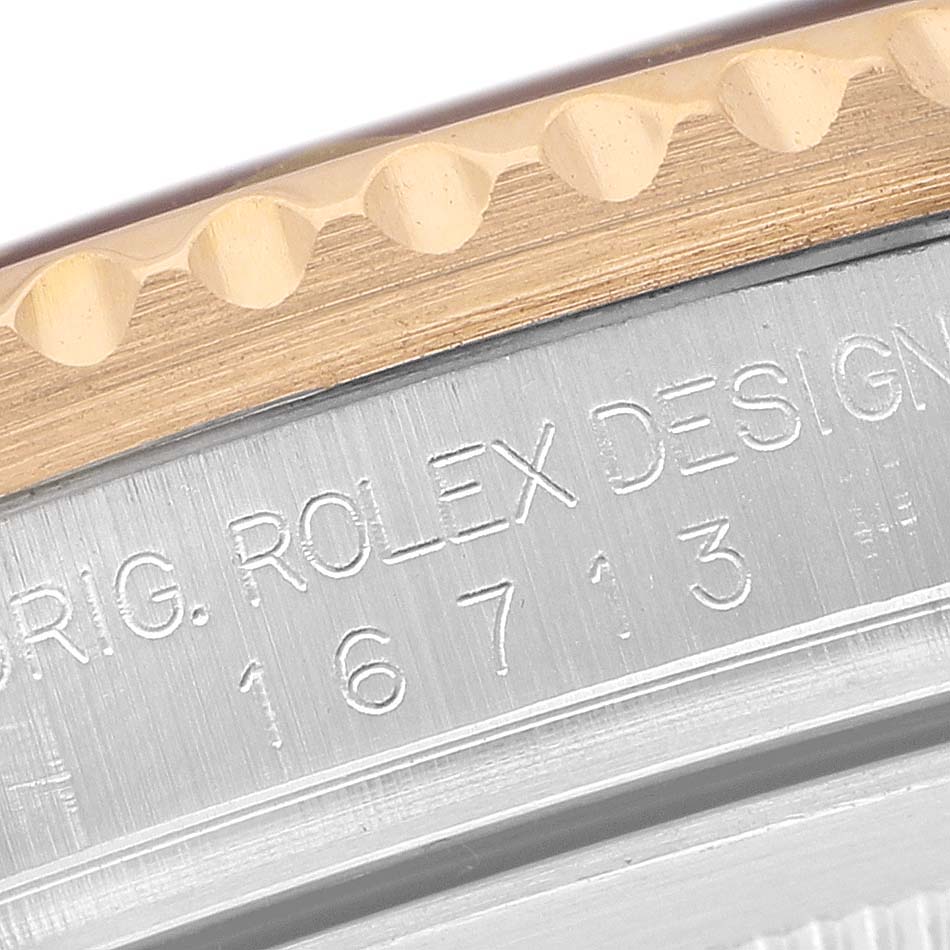 The image shows a close-up of the engraving on the side of a Rolex GMT-Master 16713 Men's Stainless Steel Brown Dial bezel and case, highlighting the model number.