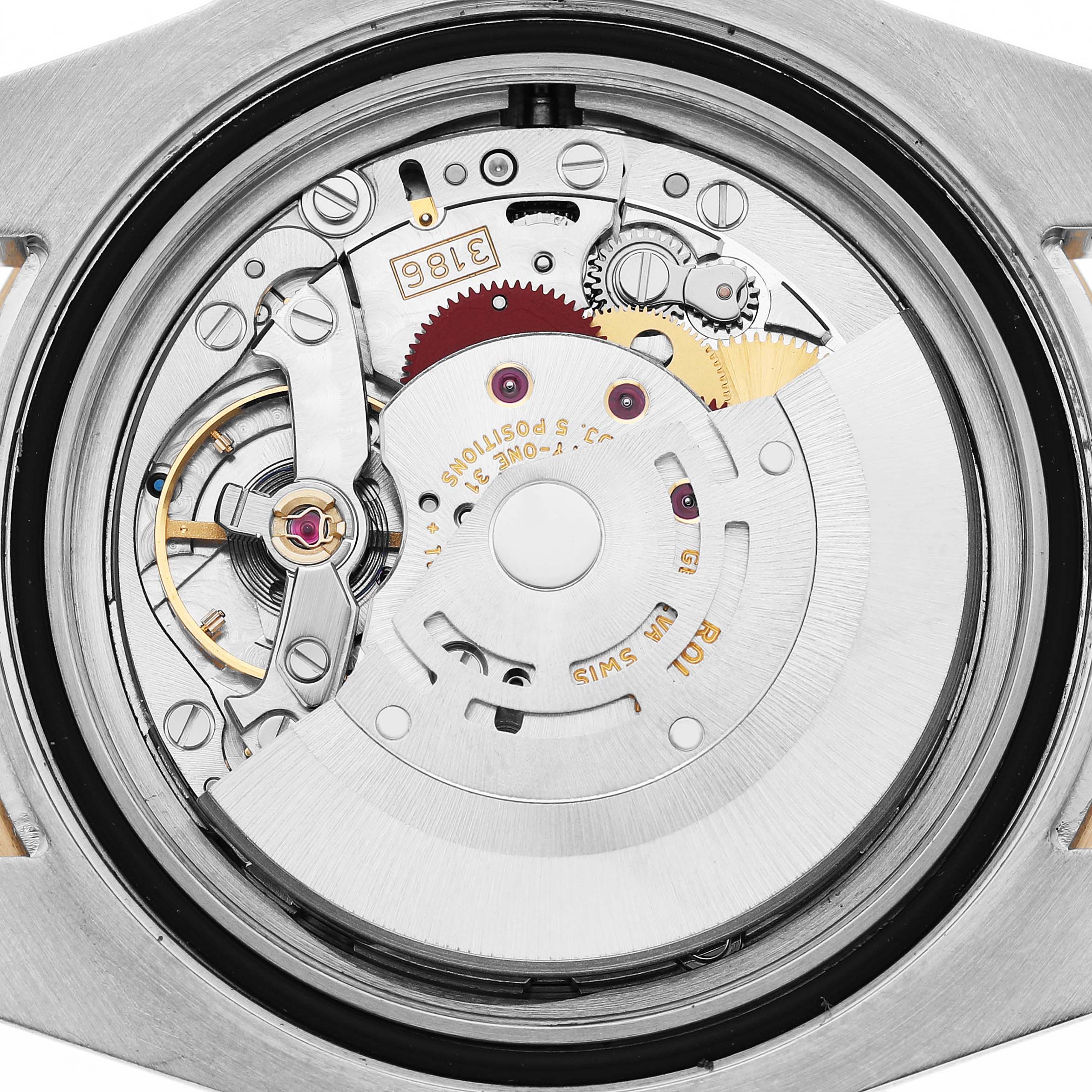 The image shows a close-up view of the movement inside a Rolex GMT-Master 116713 Men's Steel and Gold (two tone) Black Dial, highlighting gears and mechanical components.