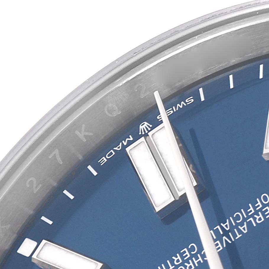 The image shows a partial view of the dial and bezel of a Rolex Oyster Perpetual watch, model number 124300, highlighting the blue face and hour markers.