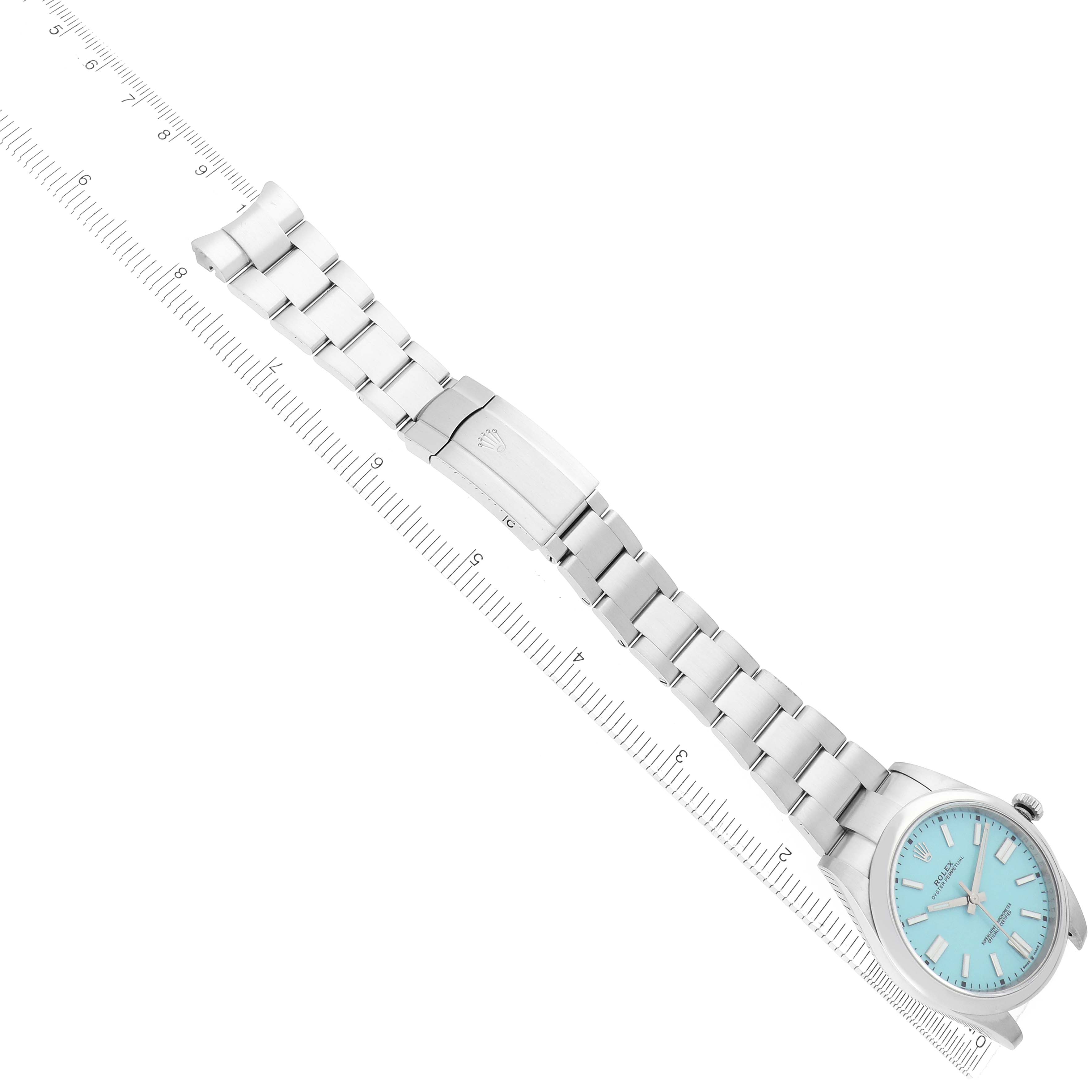 The Rolex Oyster Perpetual model 124300 watch is shown at a diagonal angle, highlighting the full bracelet and clasp, with a clear view of the turquoise dial.