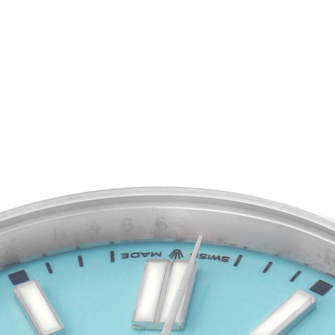 The image shows a close-up of the turquoise dial and hour markers of the Rolex Oyster Perpetual model 124300 men
s watch.