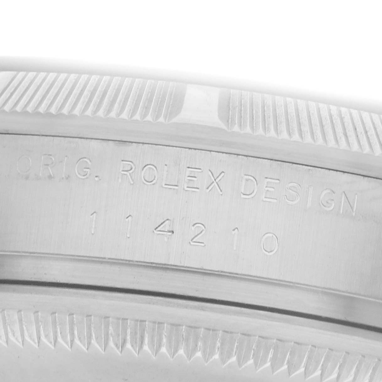 The image shows a close-up angle of the case side, engraved with "ORIG. ROLEX DESIGN 114210" from the Rolex Air-King model number 114210.