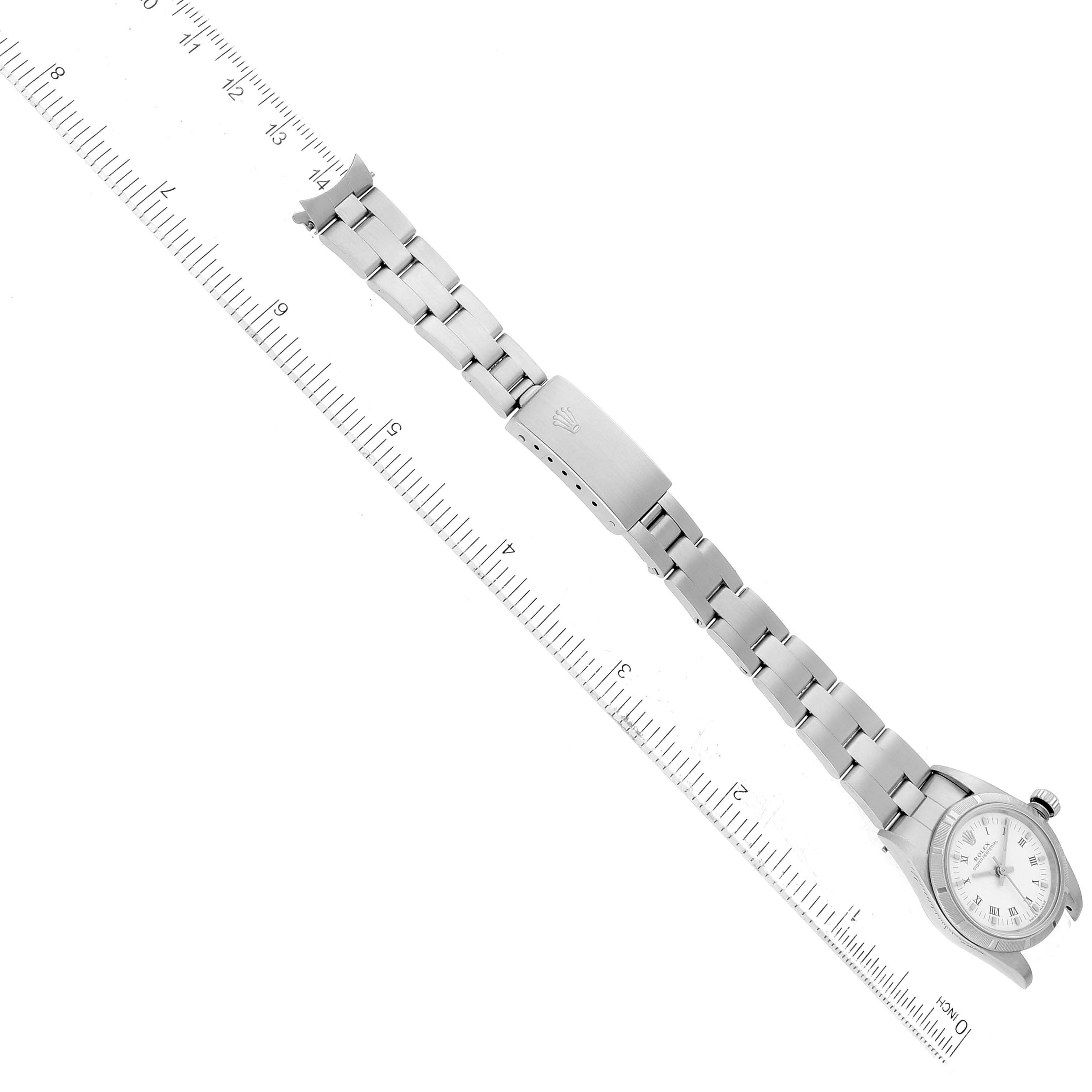 The image shows a Rolex Oyster Perpetual 76030 Women's Stainless Steel White Dial 76030 Women's Stainless Steel White Dial watch laid out flat with a ruler for scale, showcasing its bracelet and face.