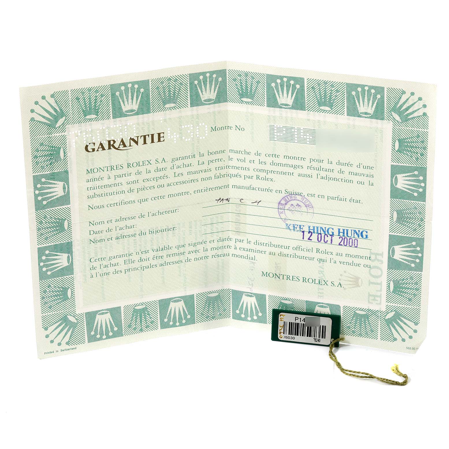 The image shows a warranty certificate for a Rolex Oyster Perpetual 76030 Women's Stainless Steel White Dial 76030 Women's Stainless Steel White Dial watch, including a green-bordered paper with logos and a tag.