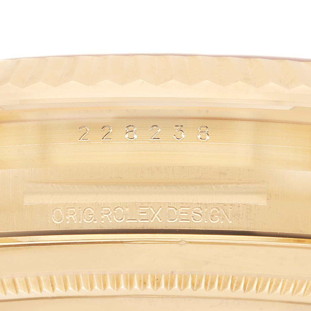 The image shows a close-up of the Rolex President model 228238, highlighting the engraved model number and "ORIG. ROLEX DESIGN" on the watch
s side.