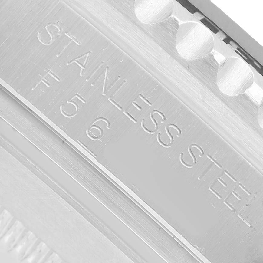 The image shows a close-up of the stainless steel bracelet of a Rolex Submariner 16610 Men's Stainless Steel Black Dial, highlighting the engraving.