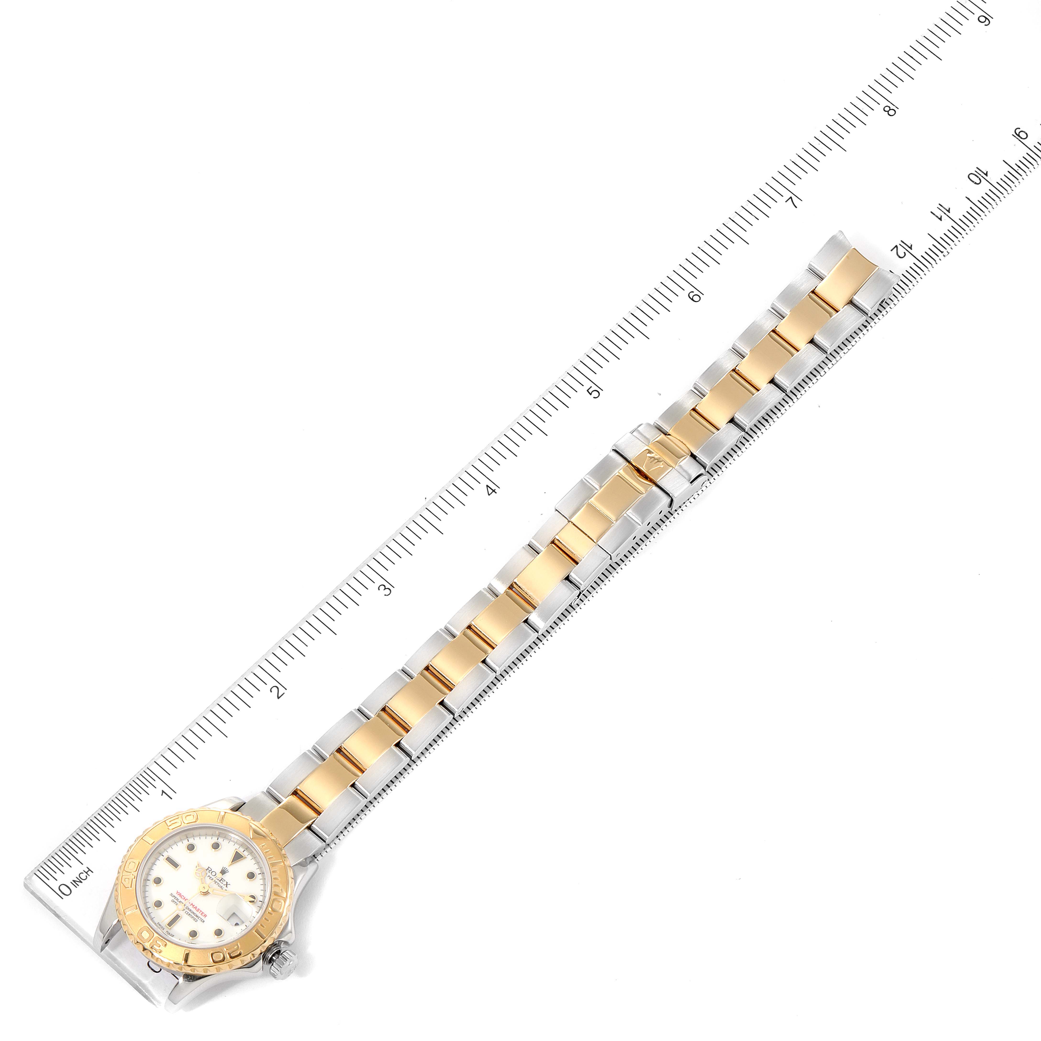 The Rolex Yacht-Master 169623 Women's Steel and Gold (two tone) White Dial 169623 Women's Steel and Gold (two tone) White Dial watch is shown from a top-down angle along with a measuring ruler.