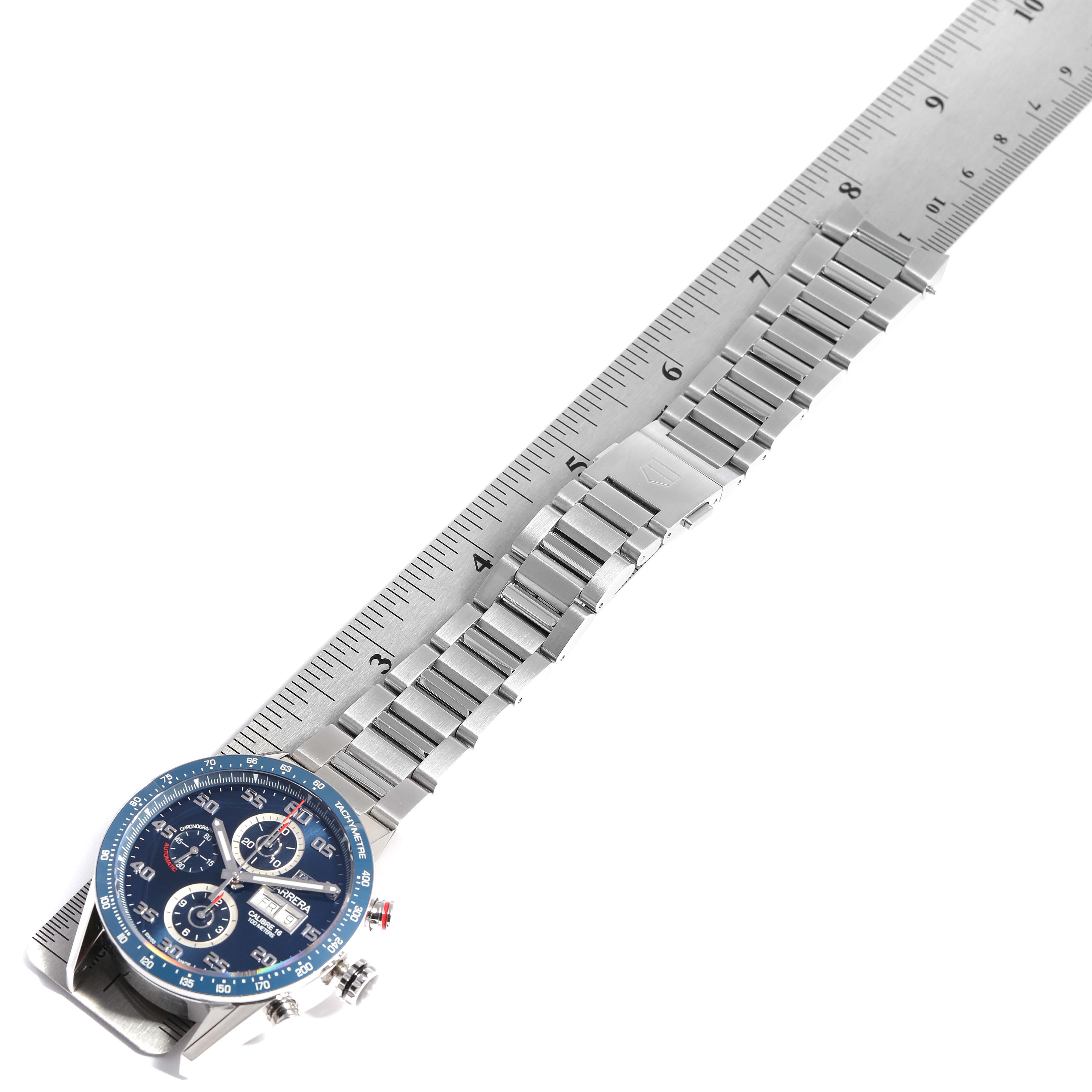 The image shows a top view of the Tag Heuer Carrera CV2A1V.BA0738 Men
s Stainless Steel Blue Dial CV2A1V.BA0738 Men
s Stainless Steel Blue Dial watch with its stainless steel band extended along a ruler.