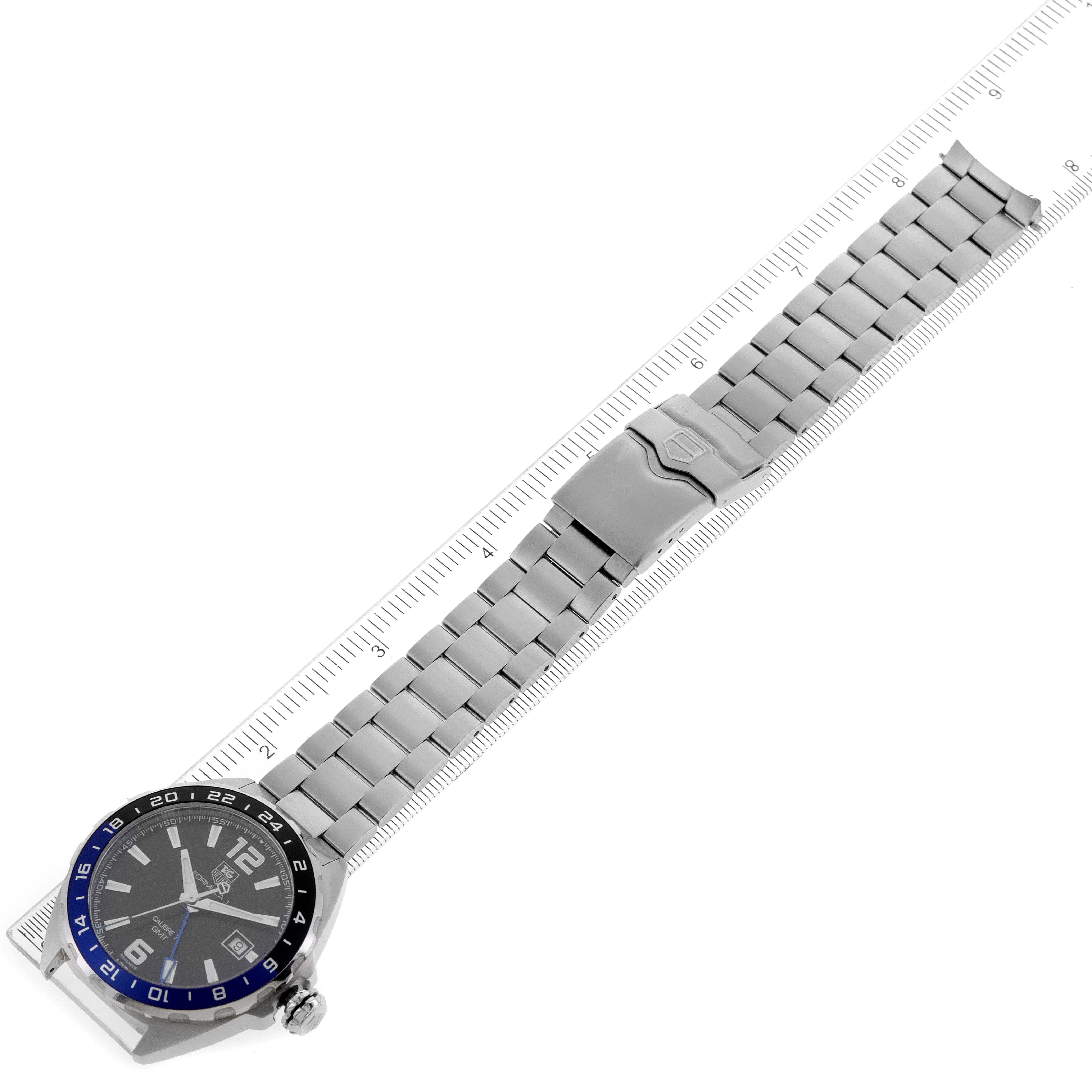 The Tag Heuer Formula 1 WAZ211A.BA0875 Men's Stainless Steel Black Dial WAZ211A.BA0875 Men's Stainless Steel Black Dial watch is shown from a top-down angle, displaying the entire band and face alongside a ruler for size reference.