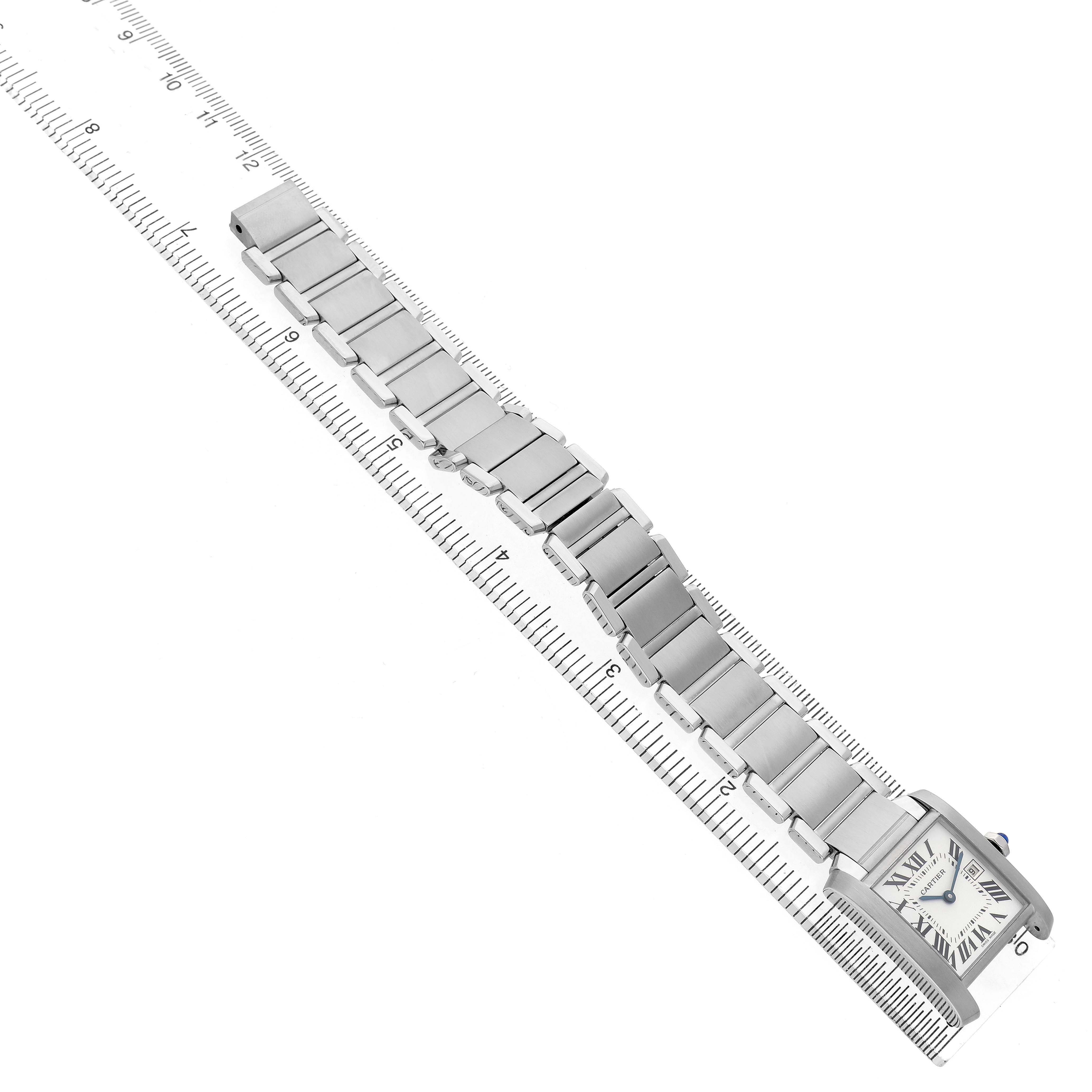 The Cartier Tank Francaise W51011Q3 Women's Stainless Steel Silver Dial watch is angled diagonally, showing its bracelet and square face against a ruler.