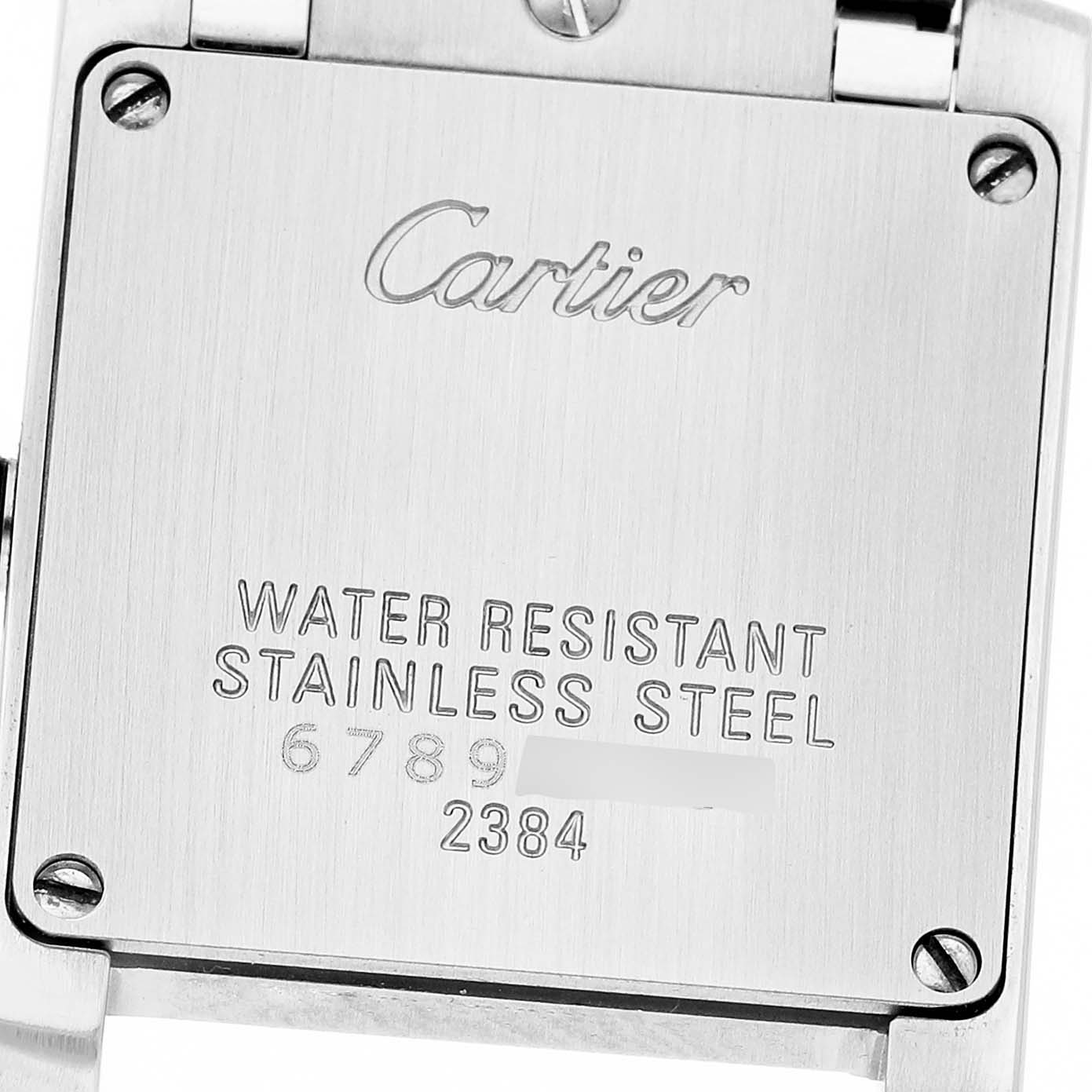 The image shows the stainless steel case back of a Cartier Tank Française watch, displaying its brand, material, and serial numbers.