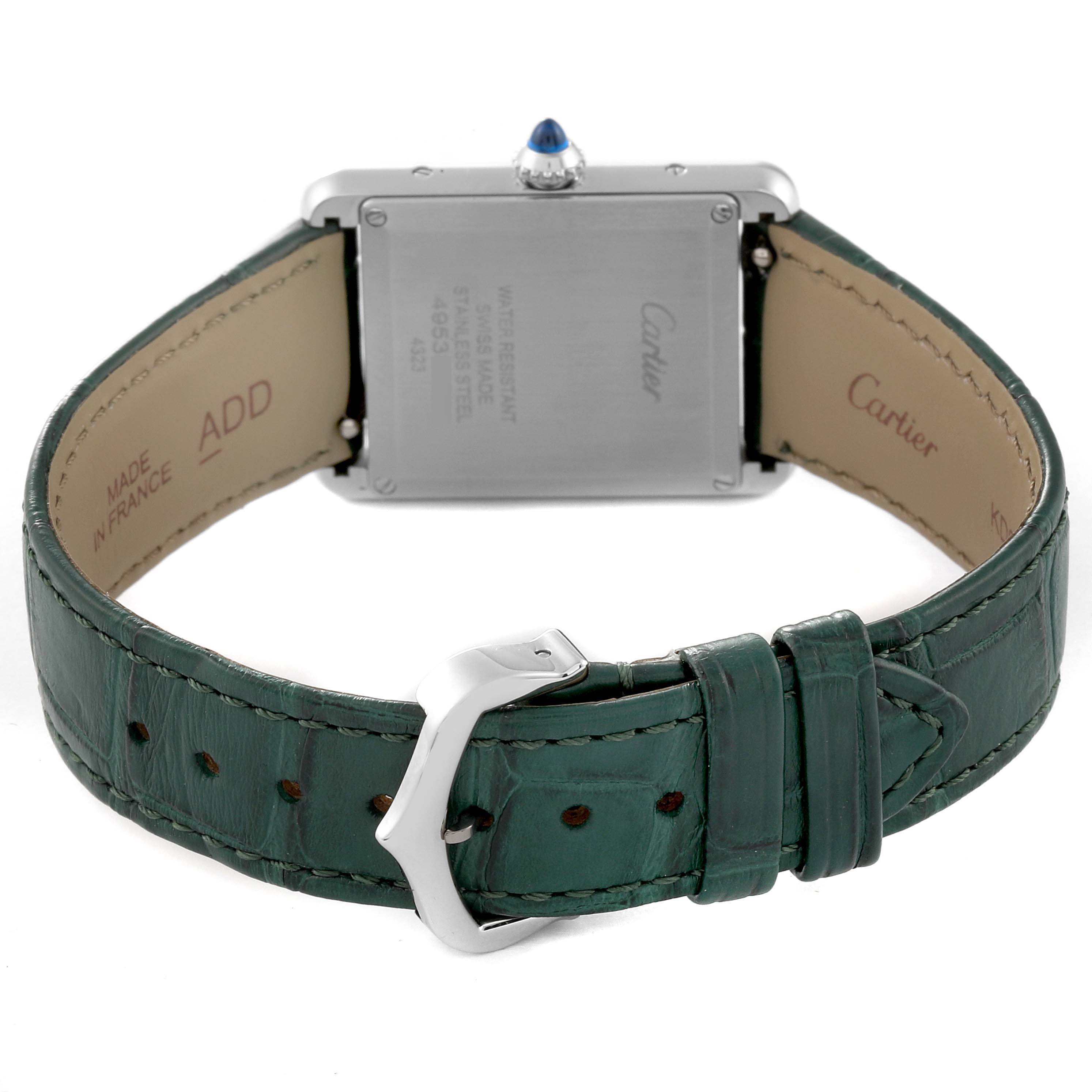 The image shows the back of a Tank Must model by Cartier, focusing on the case and green leather strap with buckle.