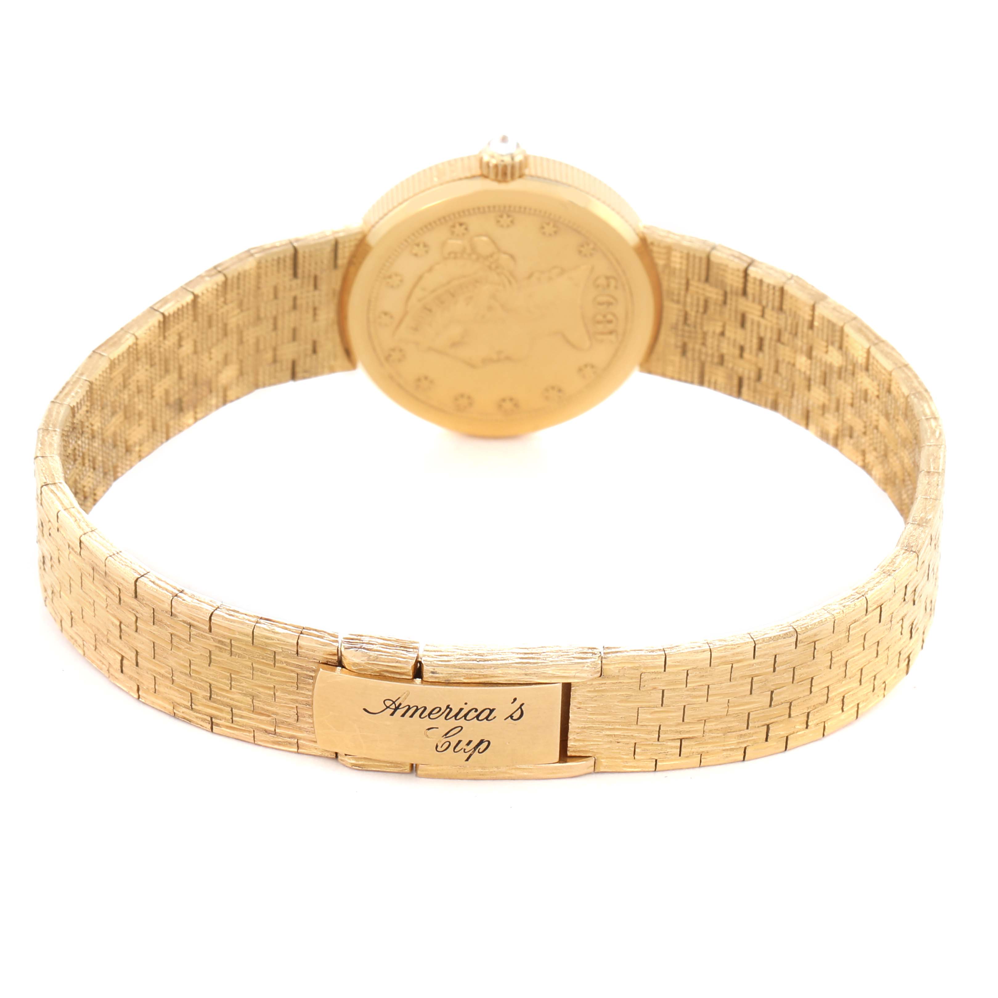 The image shows the back of a Corum model 1892 YEAR men
s watch, highlighting the engraved clasp and coin-style case back.