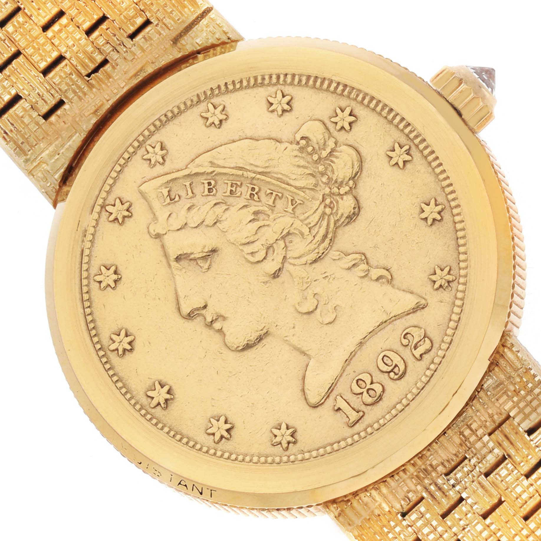 The Corum model 1892 YEAR watch is shown from a top angle, displaying the face with a coin design and part of the textured band and crown.