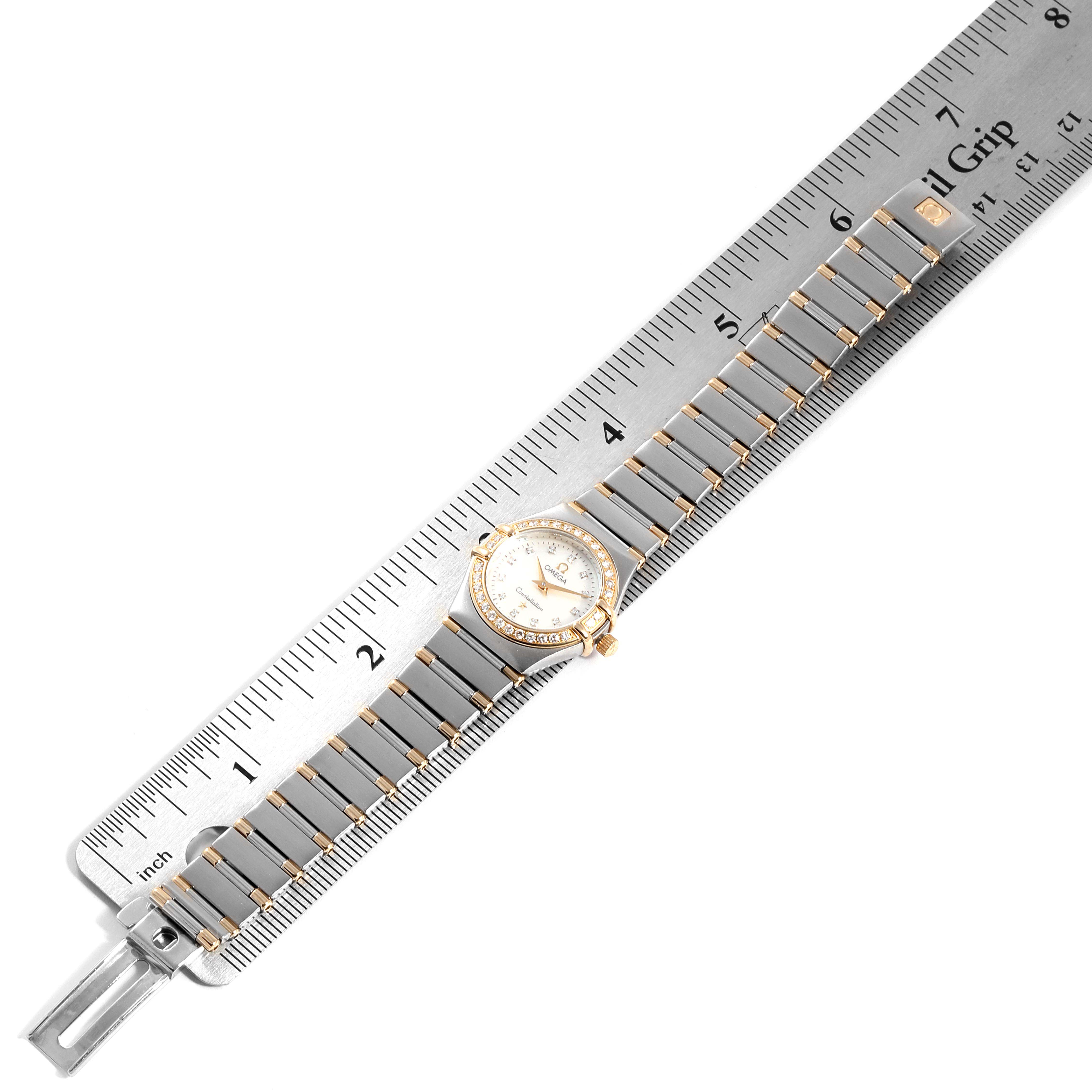 The image shows an Omega 1267.75.00 Women's Steel and Gold (two tone) Mother of Pearl Dial 1267.75.00 Women's Steel and Gold (two tone) Mother of Pearl Dial Constellation 95 Mother of Pearl Diamond Ladies Watch 1267.75.00 laid flat with a ruler.