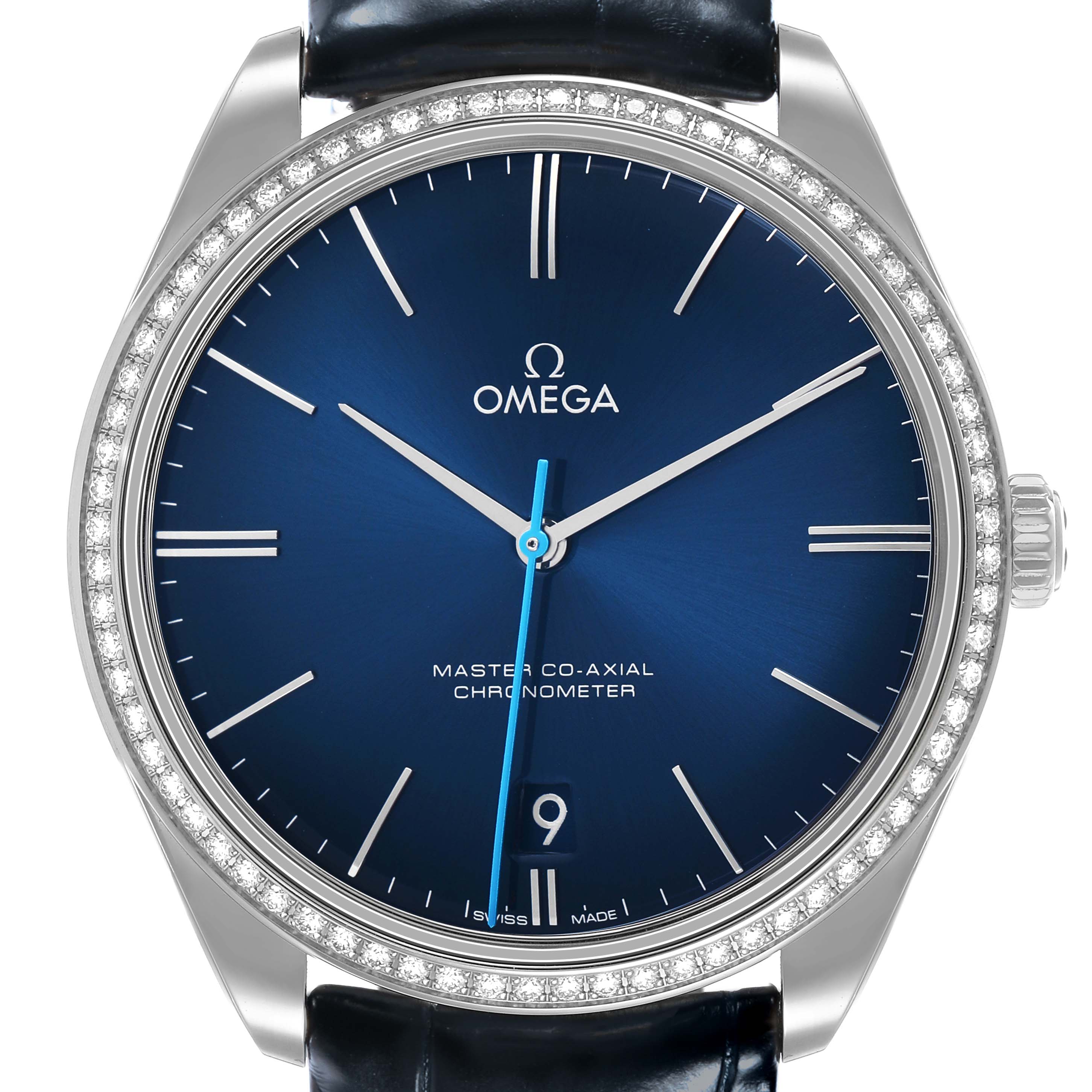 The Omega De Ville 432.18.40.21.03.001 Men's Stainless Steel Blue Dial watch is shown from a front angle, highlighting its blue dial, three hands, date display, and diamond-set bezel.
