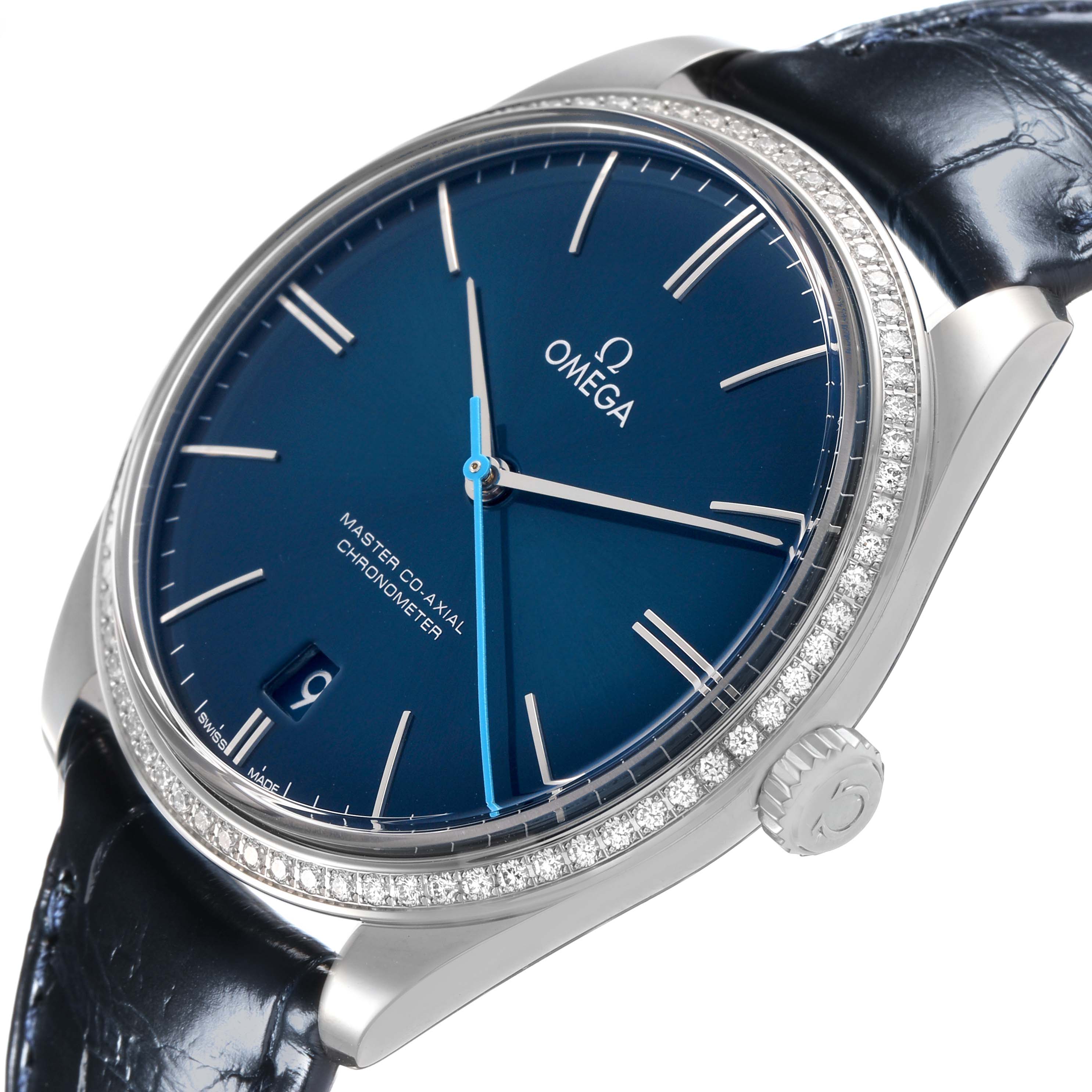 The Omega De Ville 432.18.40.21.03.001 Men's Stainless Steel Blue Dial watch is shown at an angled view highlighting the blue dial, silver casing with diamonds, and textured strap.